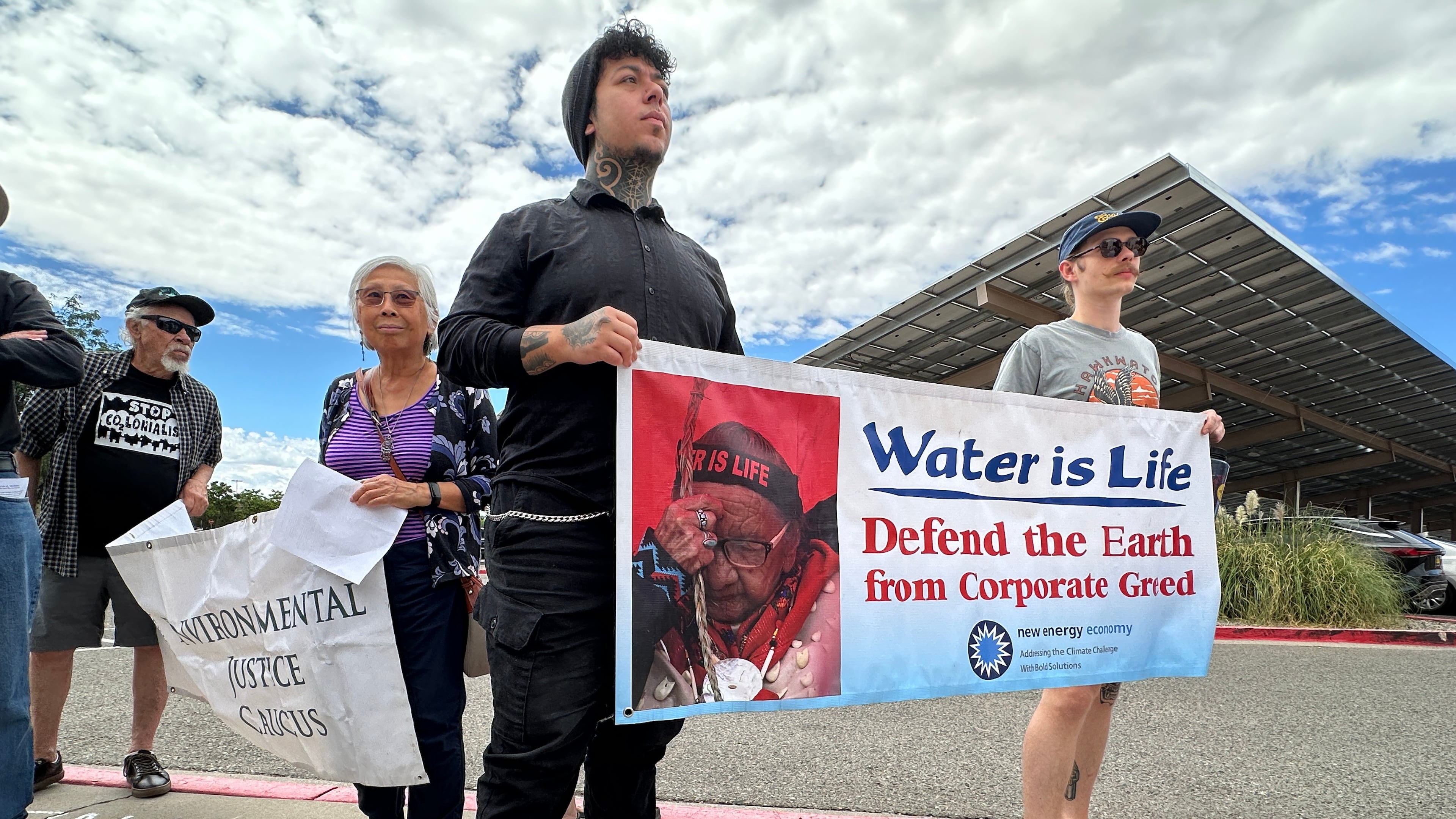 Protesters hold signs in opposition of the Project Jupiter data center during a demonstration outside a state office in Santa Fe, N.M., Friday, Aug. 21, 2026. (AP Photo/Susan Montoya Bryan)
