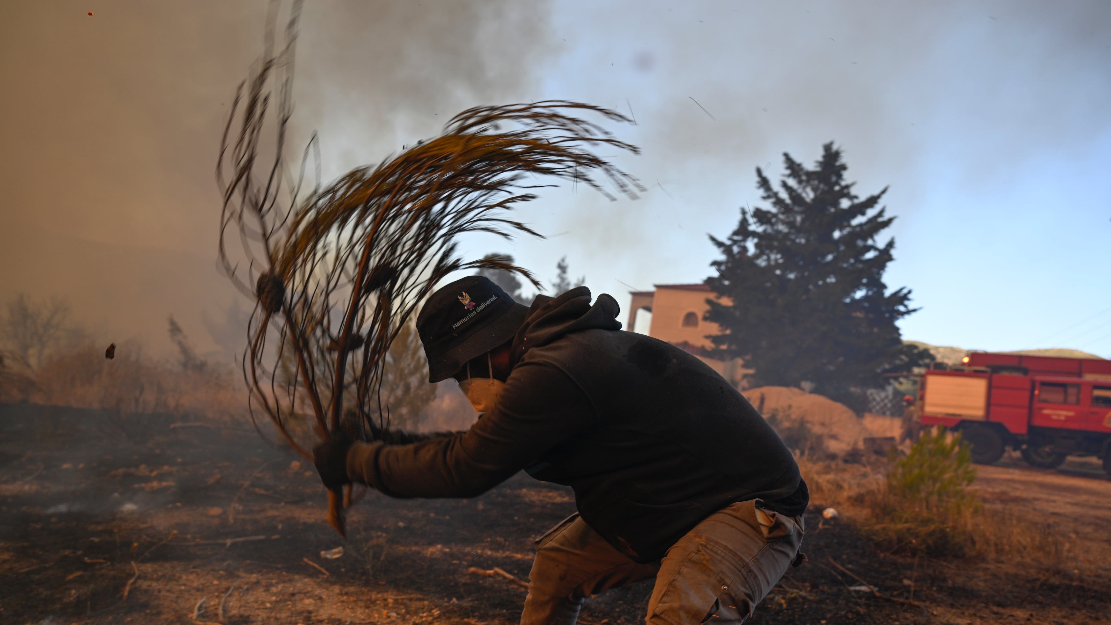 A volunteer tries to extinguish small flames during a wildfire near Porto Germeno, northwest of Athens, Greece, Sunday, Aug. 2, 2026. (AP Photo/Michael Varaklas)