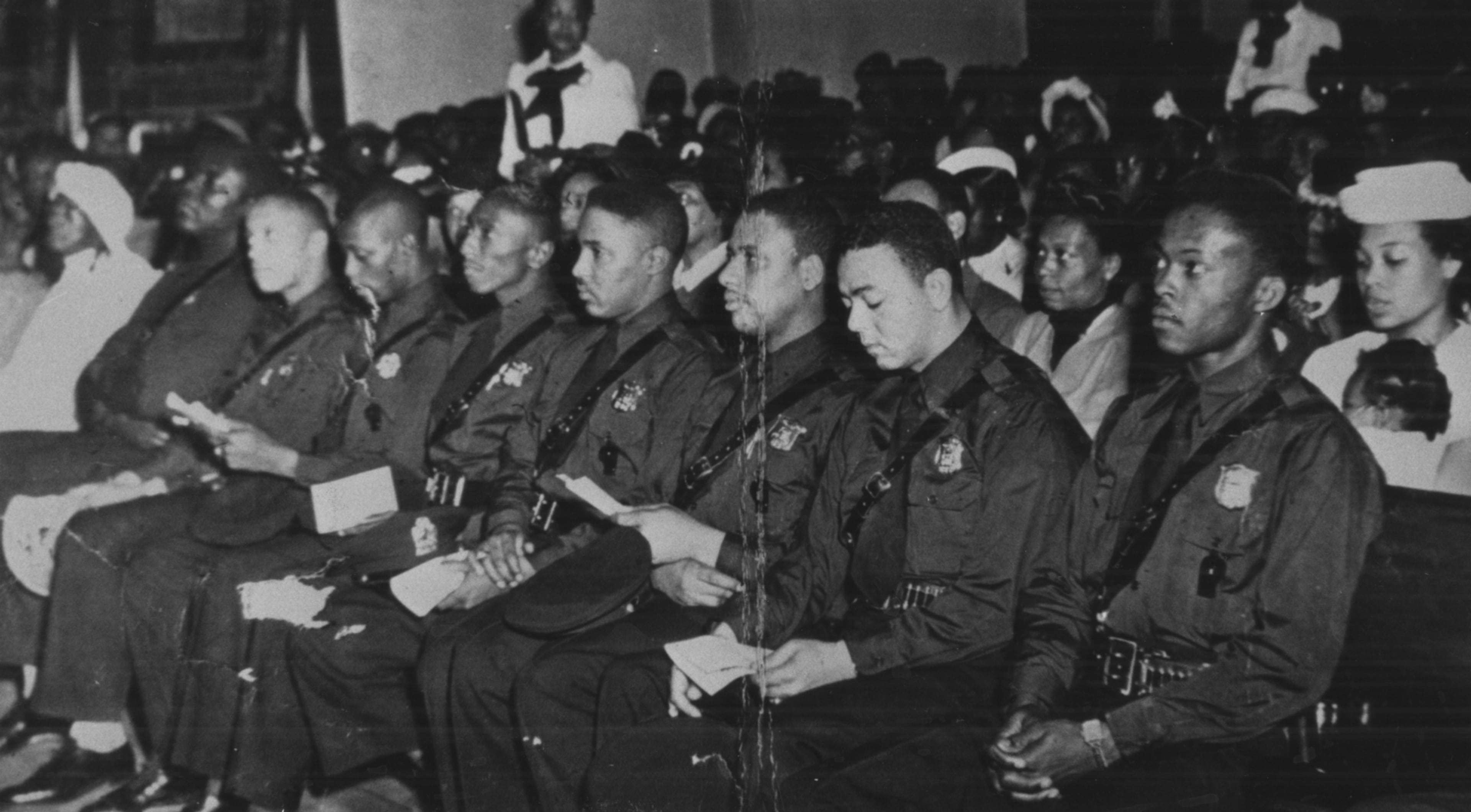 This photo taken by W.A. Scott III shows Atlanta's first eight black police officers listening to speakers during NAACP-sponsored program honoring them at Greater Mount Calvary Baptist Church on April 30, 1948. Left to right: Willie Elkins, Willard Strickland, John H. Sanders, Robert McKibbens, Ernest Lyons, Johnnie P. Jones, Henry Hooks, Claude Dixon. (Special photo by W.A. Scott III)