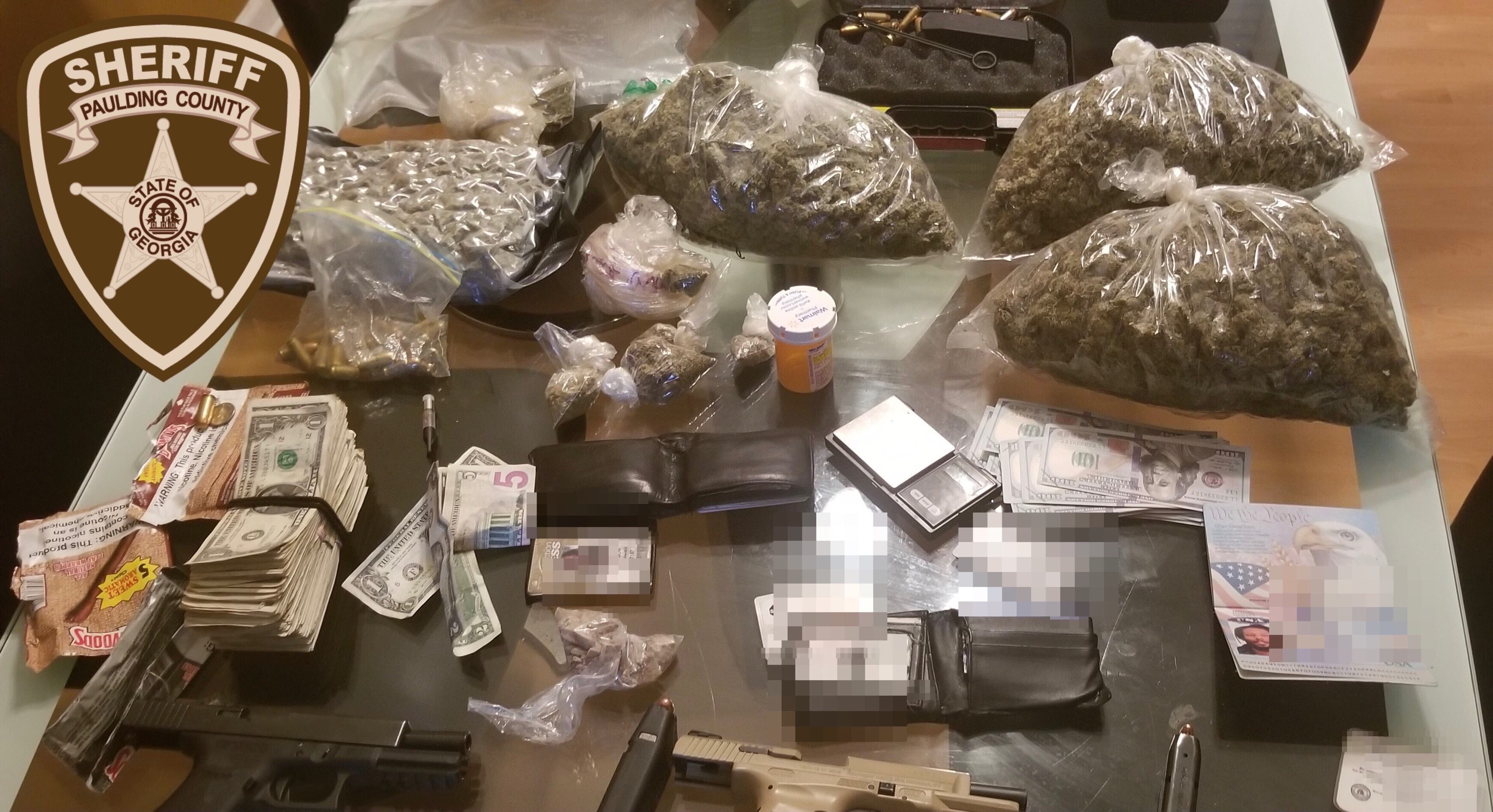 A total four pounds of marijuana, two ounces of heroin, three handguns and a substantial amount of cash were seized after a traffic stop and a raid on a south Paulding County home on Oct. 21, according to authorities.