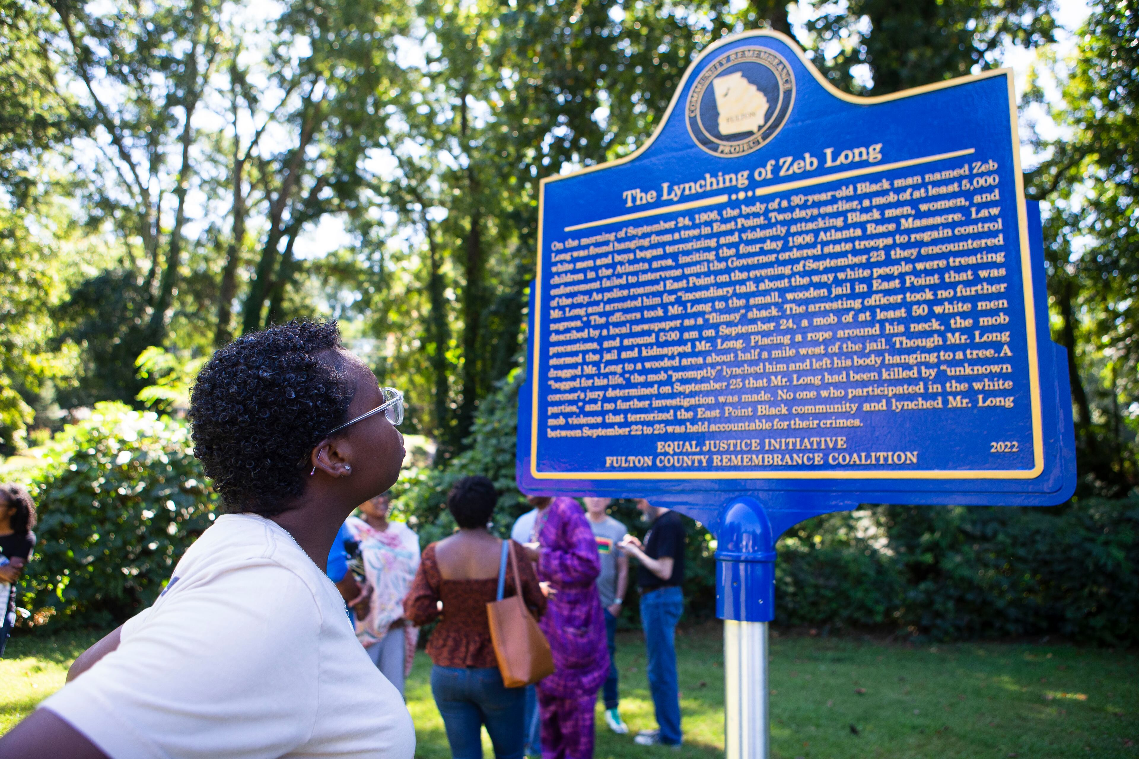 Jadori Smith reads the newly dedicated historical marker for Zeb Long, a lynching victim from the 1906 Atlanta Race Massacre, on Saturday, September 24, 2022, at Sumner Park in East Point. CHRISTINA MATACOTTA FOR THE ATLANTA JOURNAL-CONSTITUTION