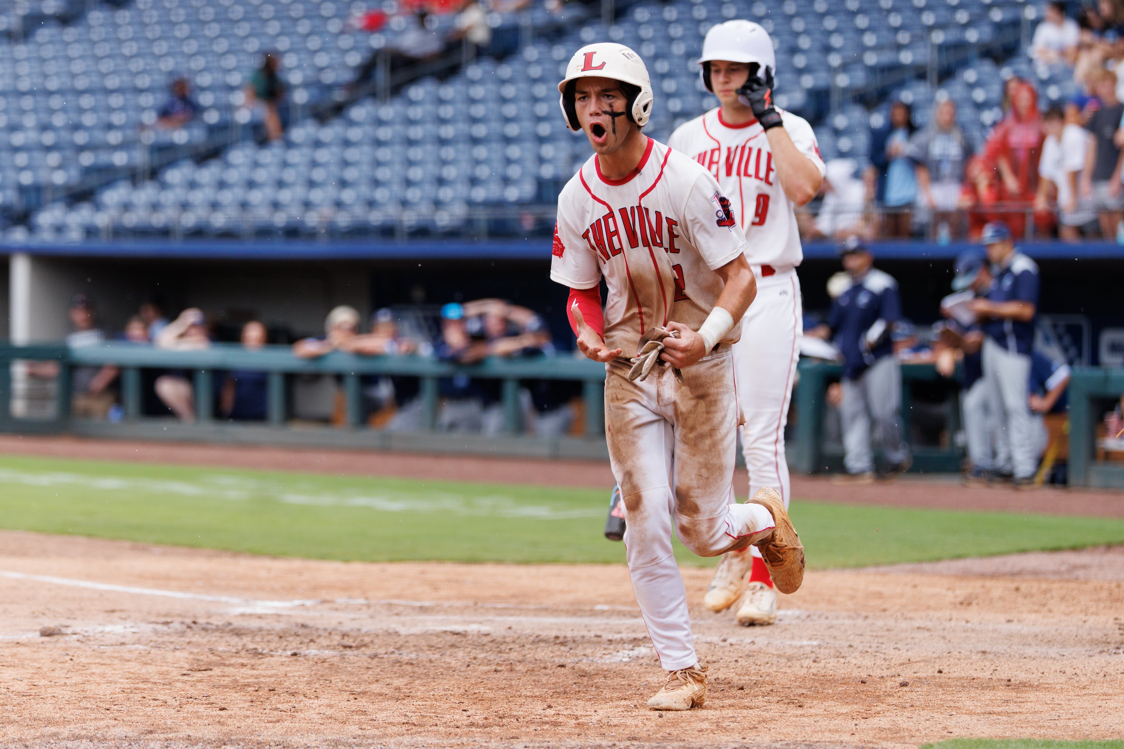 Loganville second baseman Brantley Carter (2) reacts after scoring on a scarify by Loganville Jake Boland (20) during the sixth inning of Game 1 of the GHSA Class 5A Baseball State Championship Series at Gwinnett Field on Monday, May 25, 2026, in Lawrenceville. (Estela Muñoz/AJC)