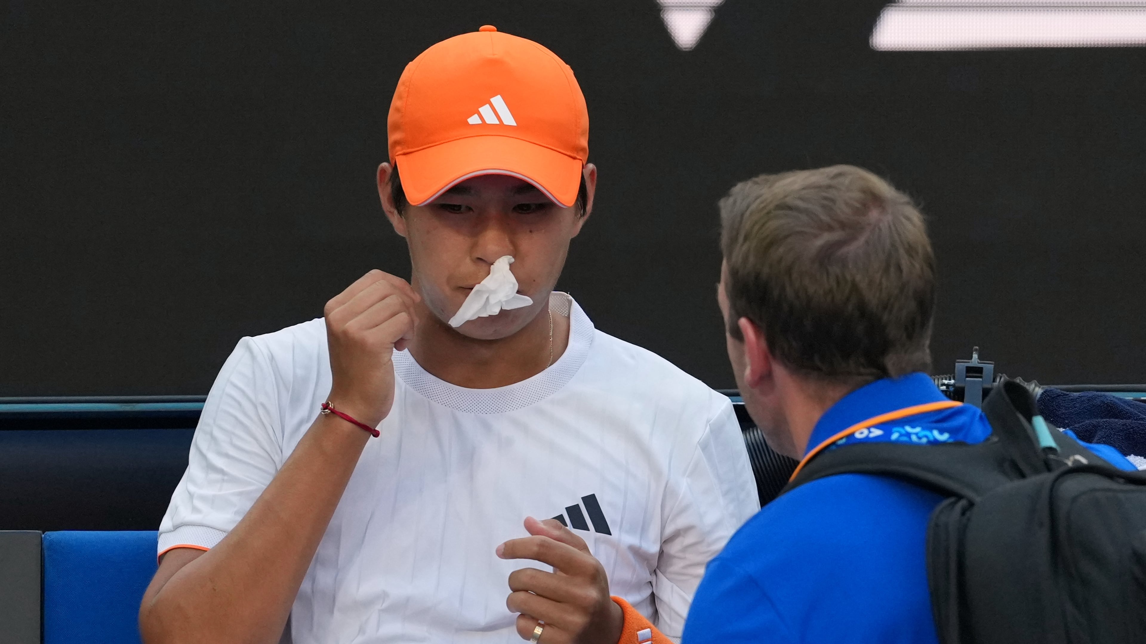 Learner Tien of the U.S. receives treatment for a nose bleed during his fourth round match against Daniil Medvedev of Russia at the Australian Open tennis championship in Melbourne, Australia, Sunday, Jan. 25, 2026. (AP Photo/Asanka Brendon Ratnayake)