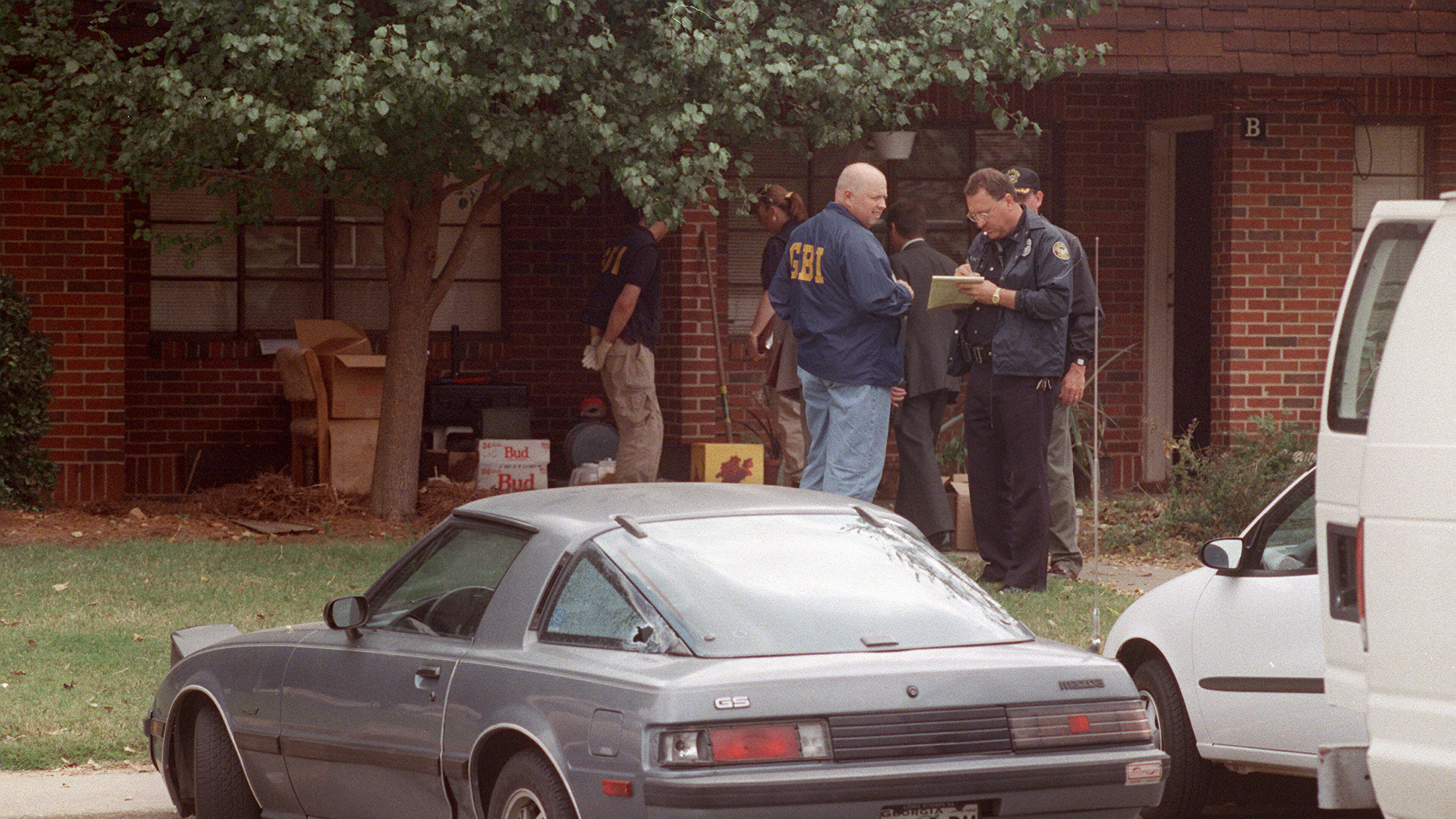 OCTOBER 1997: Officials from the GBI and the Atlanta Police Department investigate the scene where Officer John “Rick” Sowa was murdered, and his partner Officer Pat Cocciolone was wounded, on Oct. 12, 1997. (Kimberly Smith/ AJC file photo)