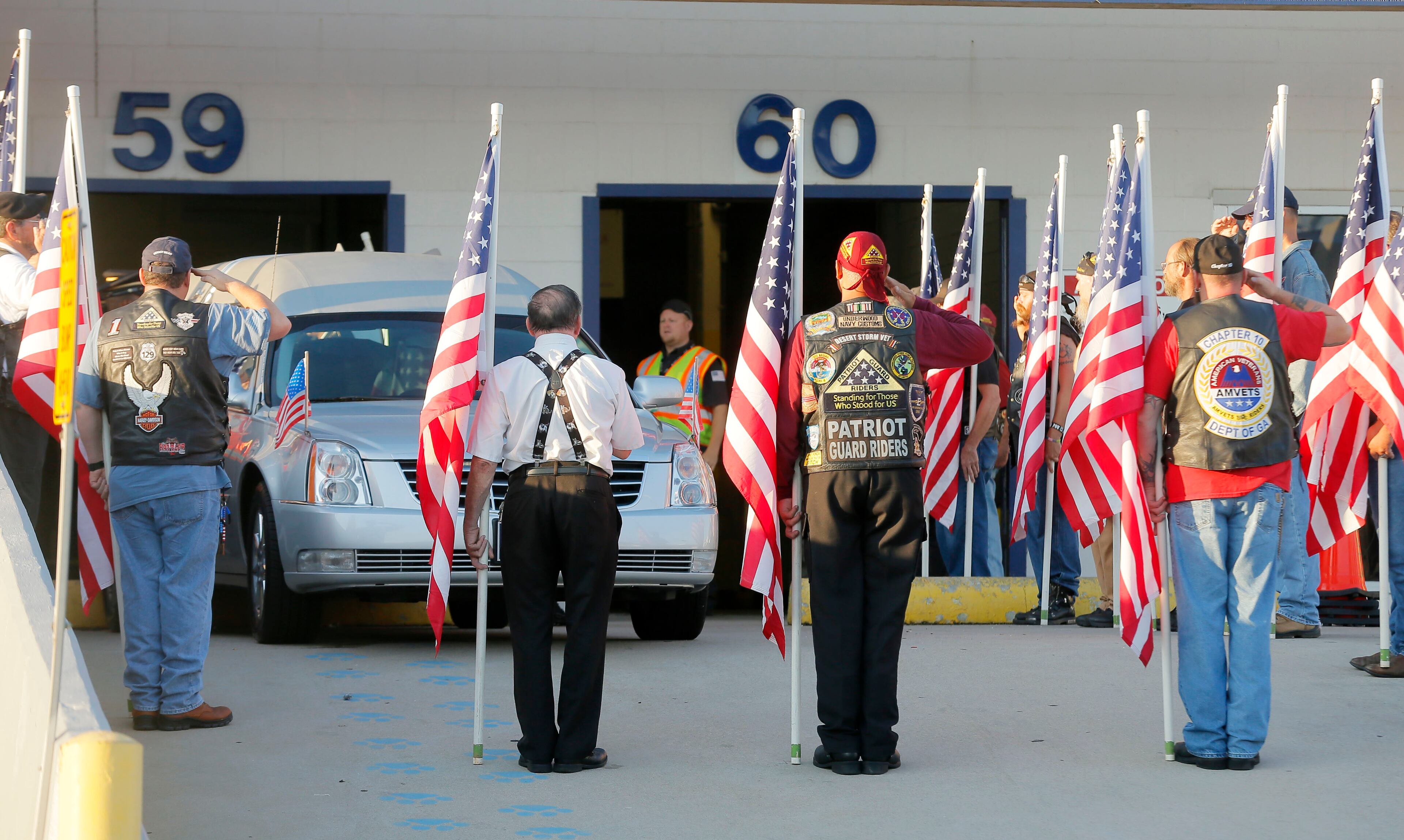 8/9/18 - Atlanta - Members of the Patriot Riders and Broken Chains salute and carry flags as the casket containing Cpl. Terrell J. Fuller is loaded into a waiting hearse. The remains of Korea War vet Cpl. Terrell J. Fuller, who went missing 67 years ago, arrived at the airport Thursday morning and was escorted to his hometown of Toccoa, where organizers planned a hero's welcome. BOB ANDRES /BANDRES@AJC.COM