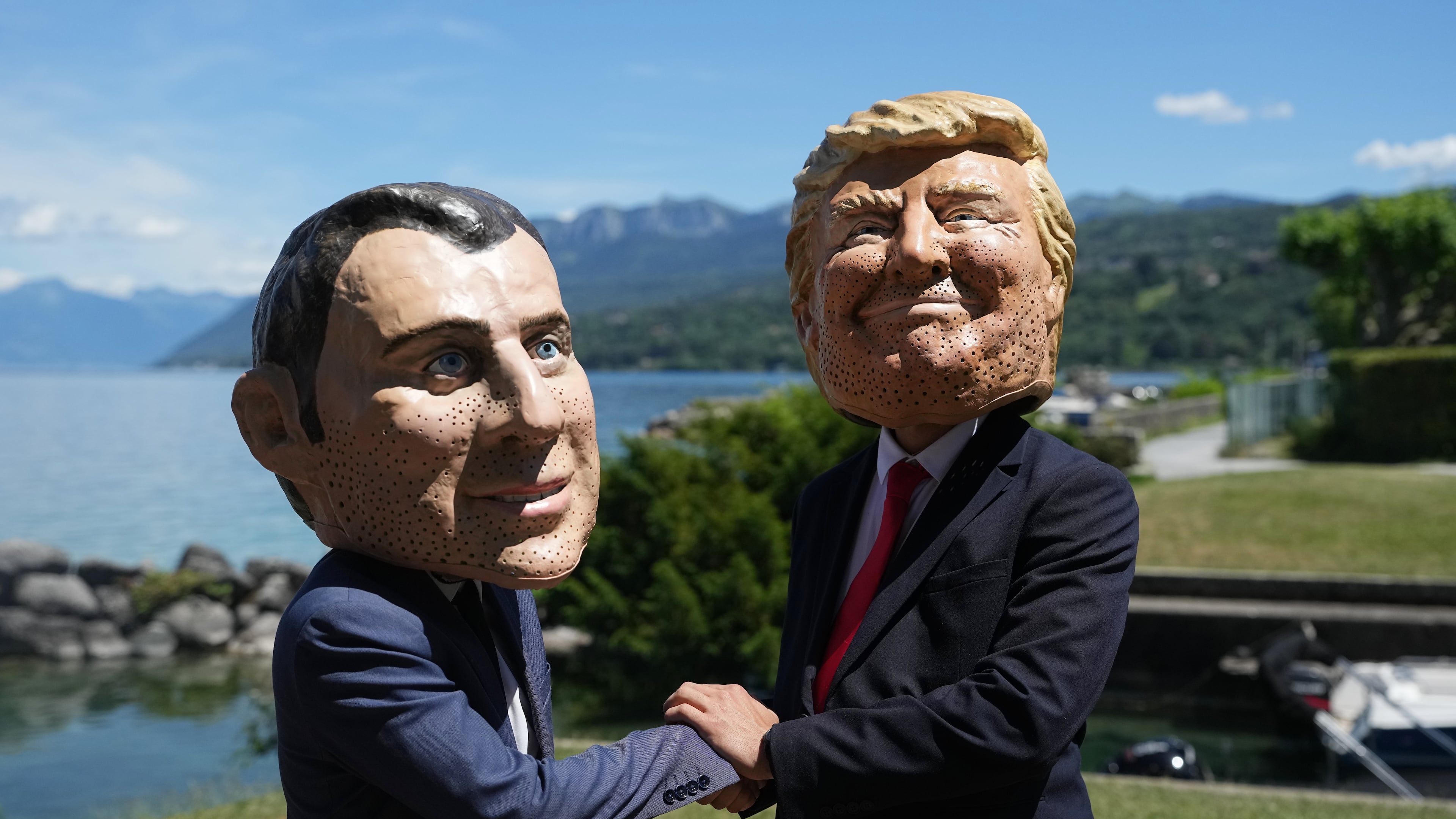 Oxfam's satirical 'big heads' of the G7 leaders depicting French President Emmanuel Macron, left, and U.S. President Donald Trump pose, in Evian-les-Bains, France, Sunday, June 14, 2026, ahead of the G7 summit scheduled to take place in France June 15-17. (AP Photo/Thibault Camus)