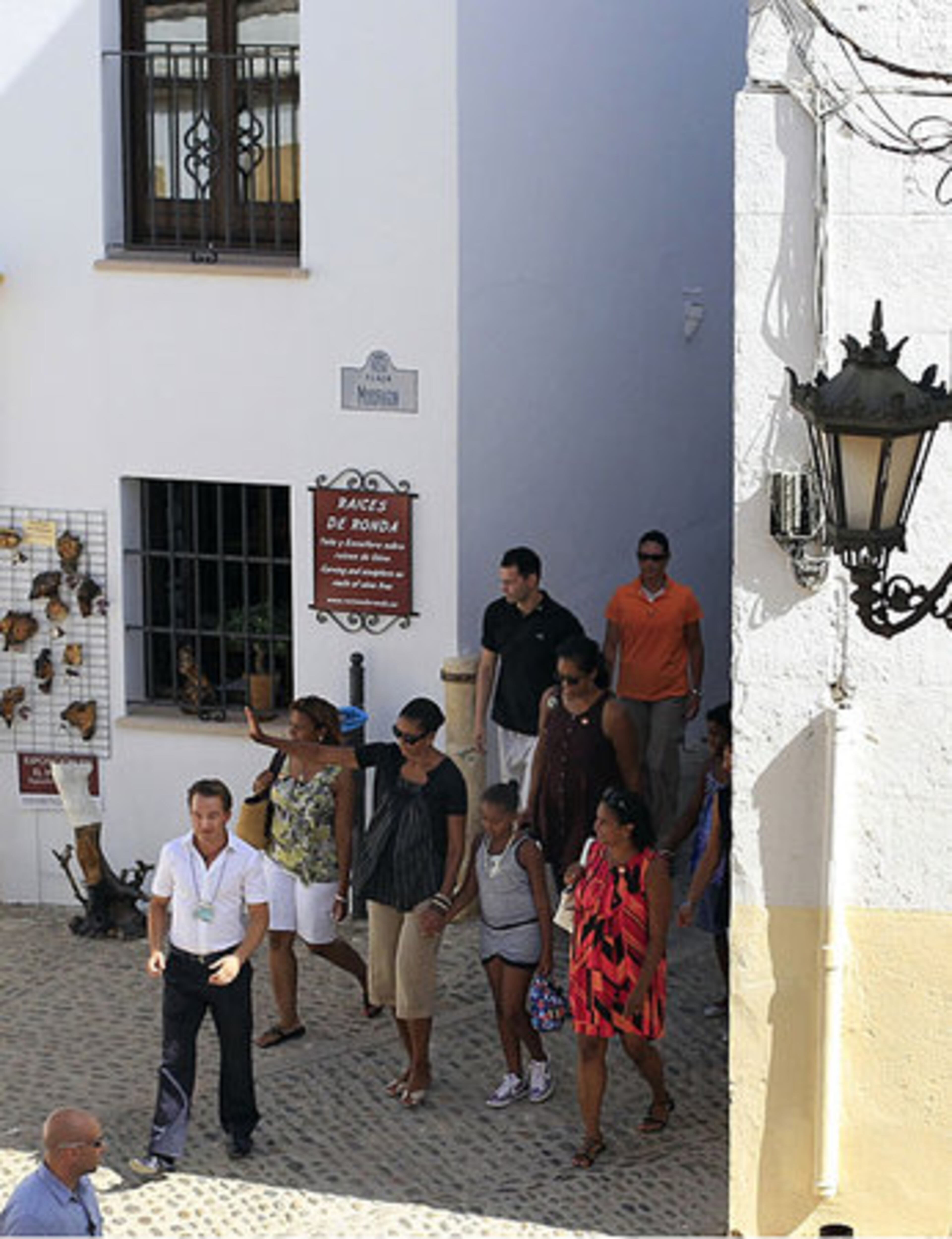 First Lady Michelle Obama, center, waves during a visit to Ronda in southern Spain, Saturday, Aug. 7, 2010.