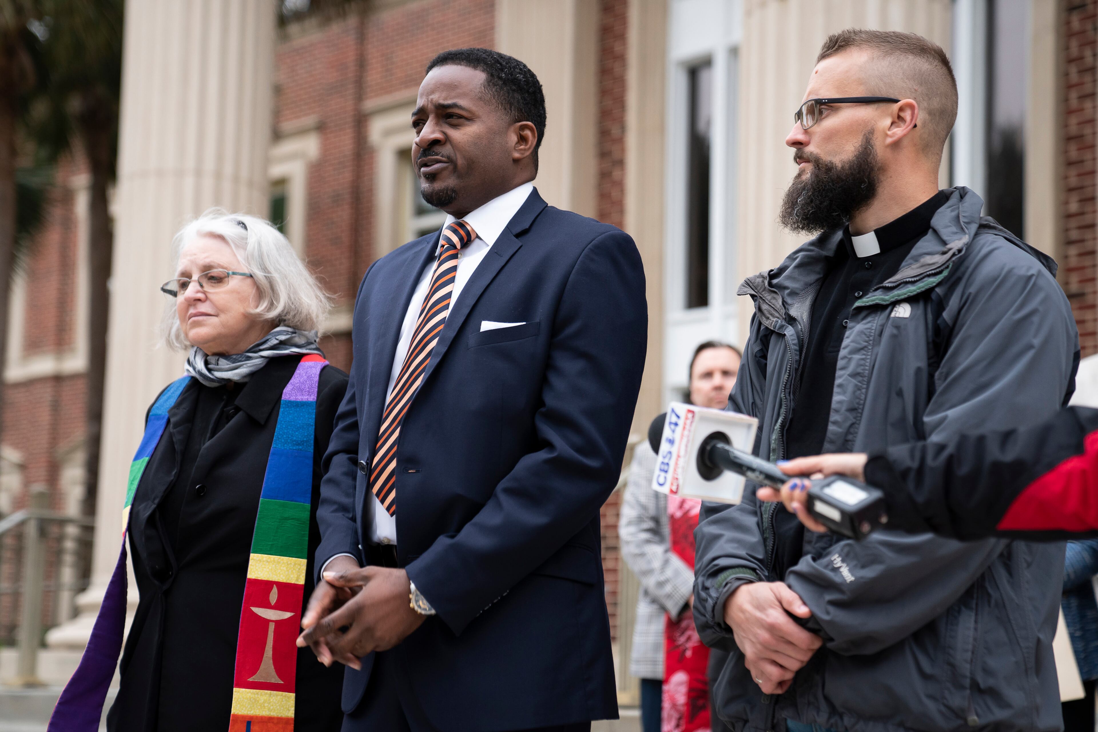 John Davis Perry II, a local minister, center, with other clergy members at Glynn County Superior Court in Brunswick, Ga., Nov. 5, 2021. The group urged the community to remain peaceful and united despite their unhappiness that a nearly all-white jury had been seated in the trial of the white men accused of killing Ahmaud Arbery, a Black man. (Nicole Craine/The New York Times)