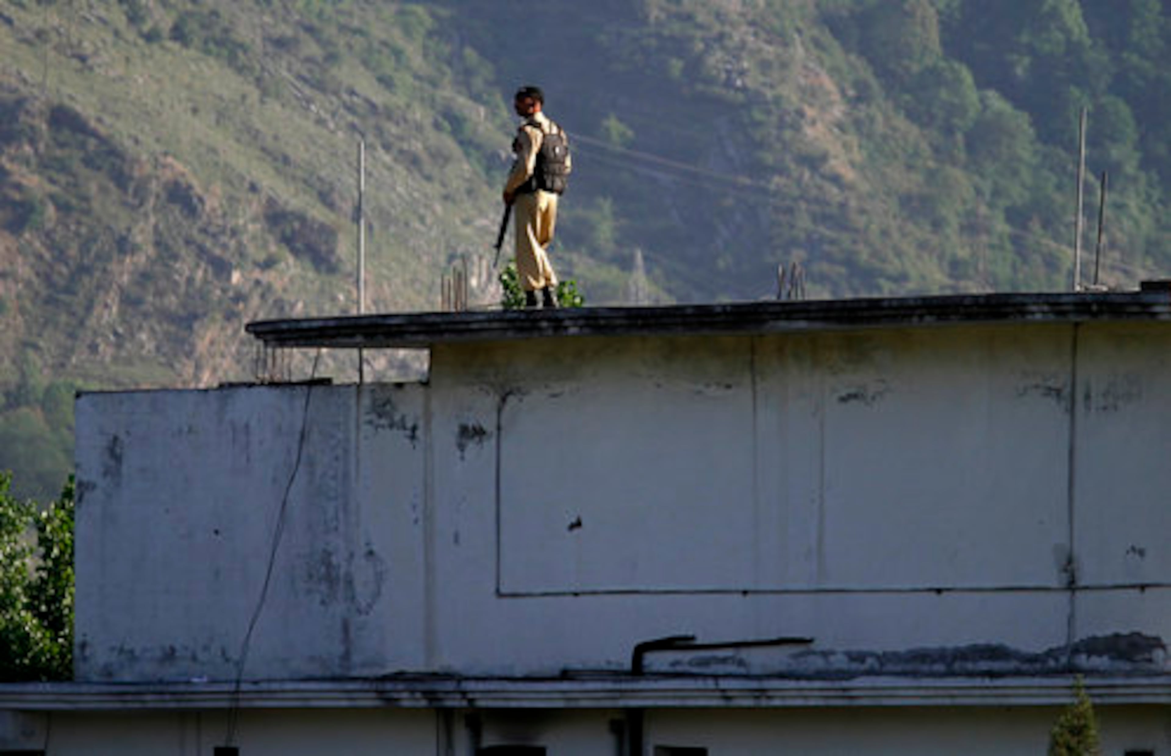 A Pakistan army soldier stands on top of the house where it is believed al-Qaida leader Osama bin Laden lived in Abbottabad, Pakistan on Monday, May 2, 2011.