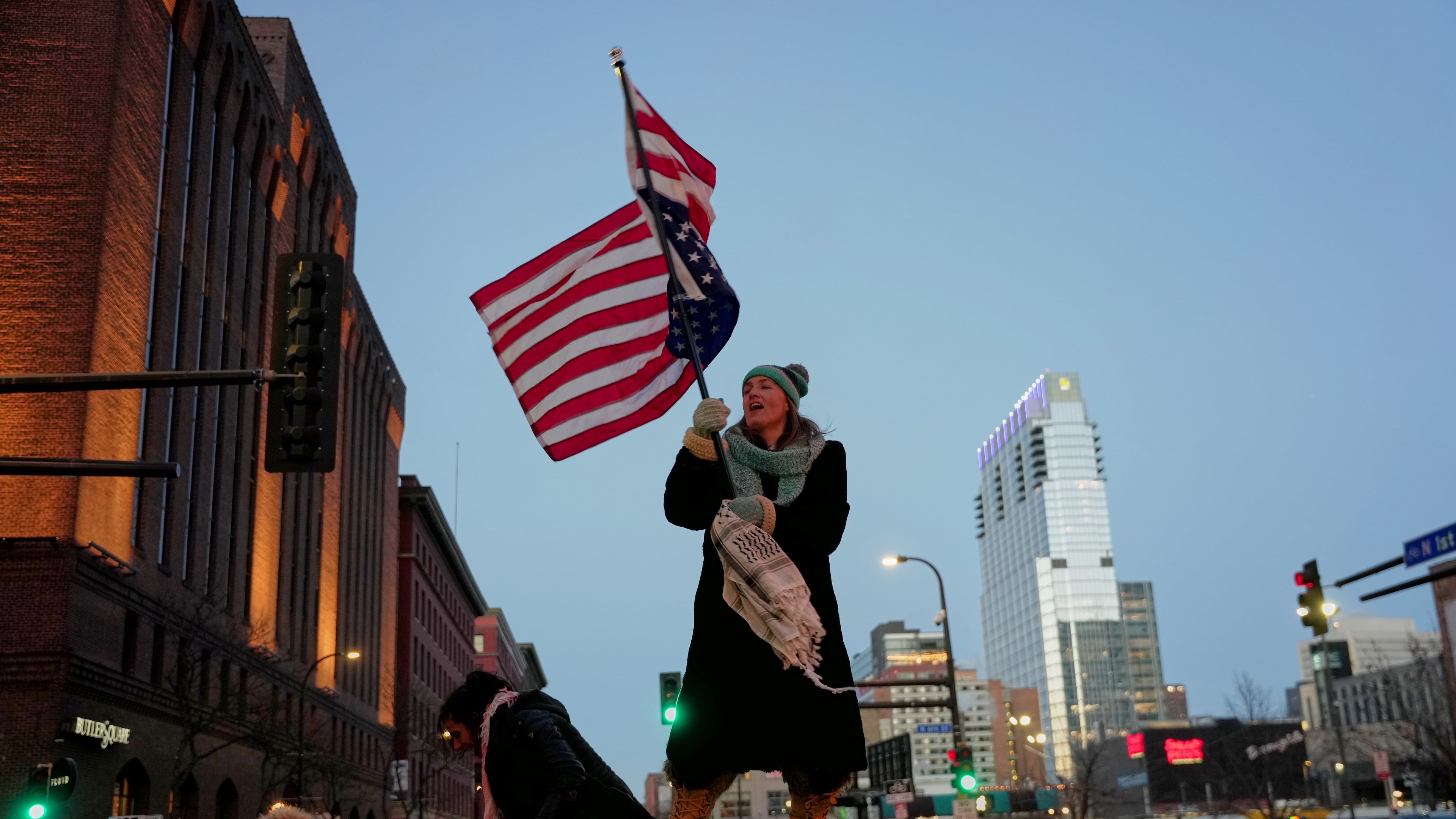 Teresa Hurst waves an upside-down American flag on top of a car during a rally against federal immigration enforcement on Friday, Jan. 23, 2026, in Minneapolis. (AP Photo/Angelina Katsanis)