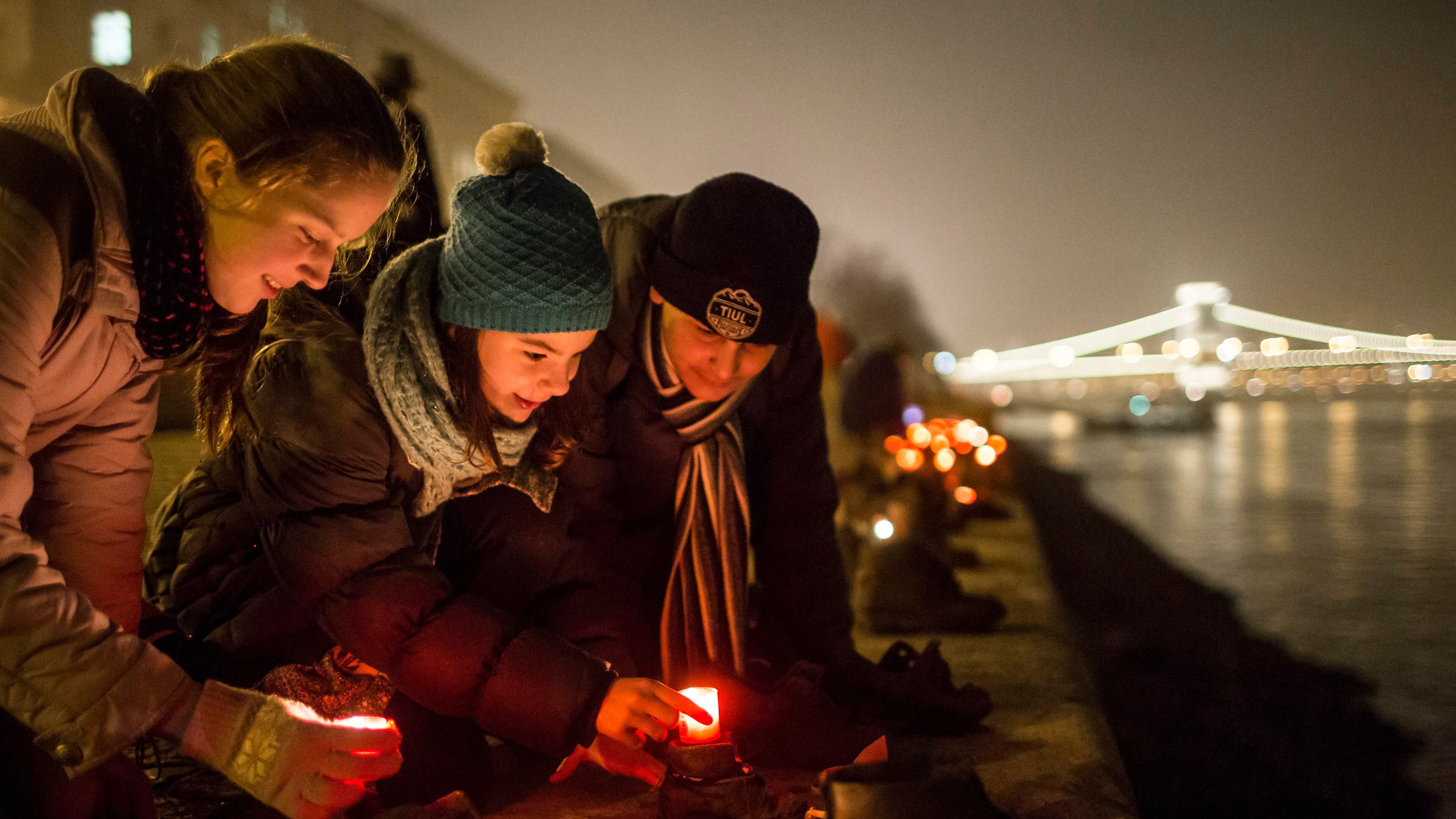 Backdropped by the illuminated Chain Bridge, people light candles in front of the cast iron shoes at the Holocaust Memorial on the quay of the River Danube, during International Holocaust Remembrance Day in Budapest, Hungary, Wednesday, Jan. 27, 2016. International Holocaust Remembrance Day marks the liberation of Auschwitz-Birkenau Nazi concentration camp by Soviet troops on Jan. 27, 1945.