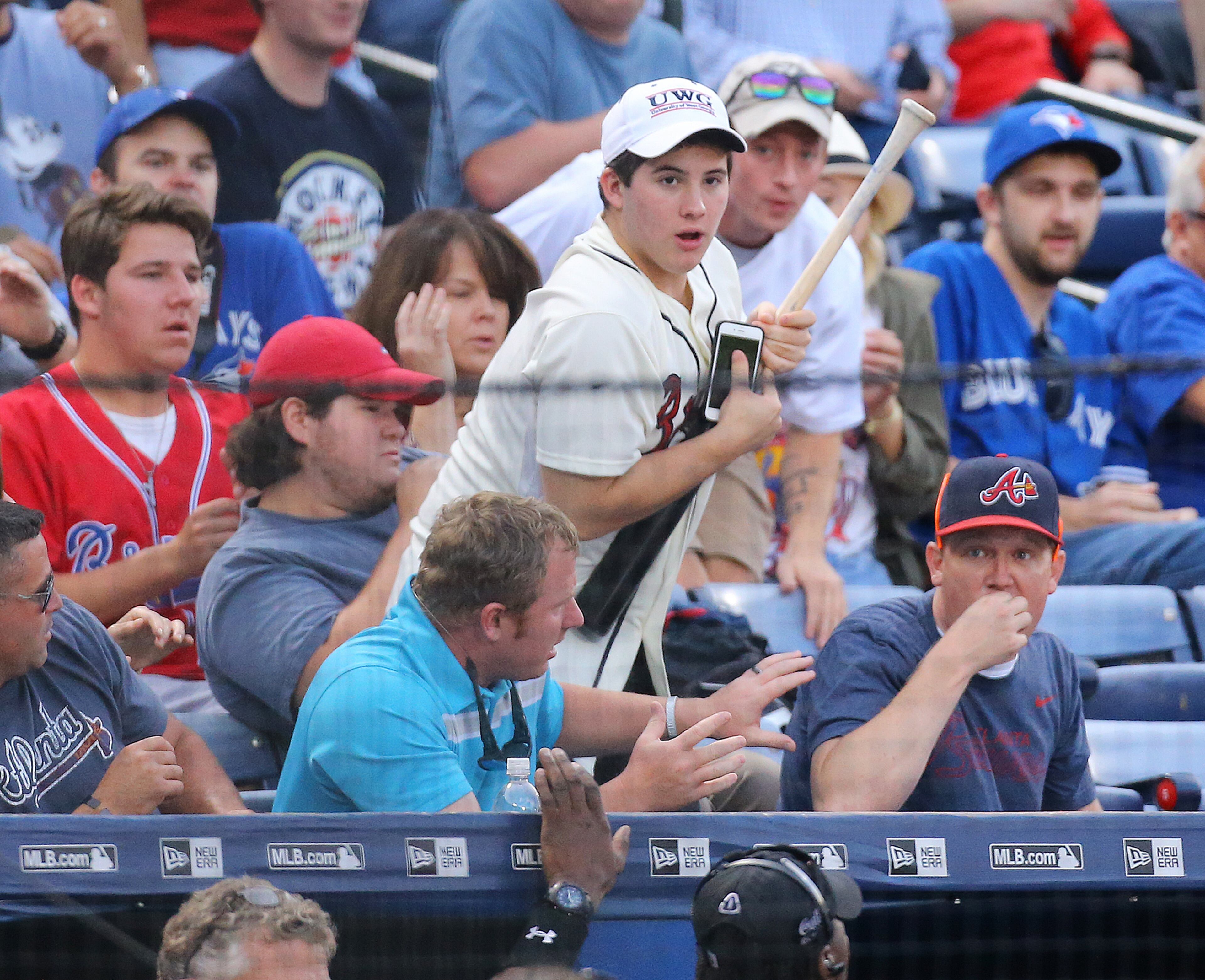 091515 ATLANTA: A Braves fan comes up with Blue Jays Josh Donaldson’s bat after he lost it into the crowd during the first inning against the Braves in a baseball game on Tuesday, Sept. 15, 2015, in Atlanta. Curtis Compton / ccompton@ajc.com
