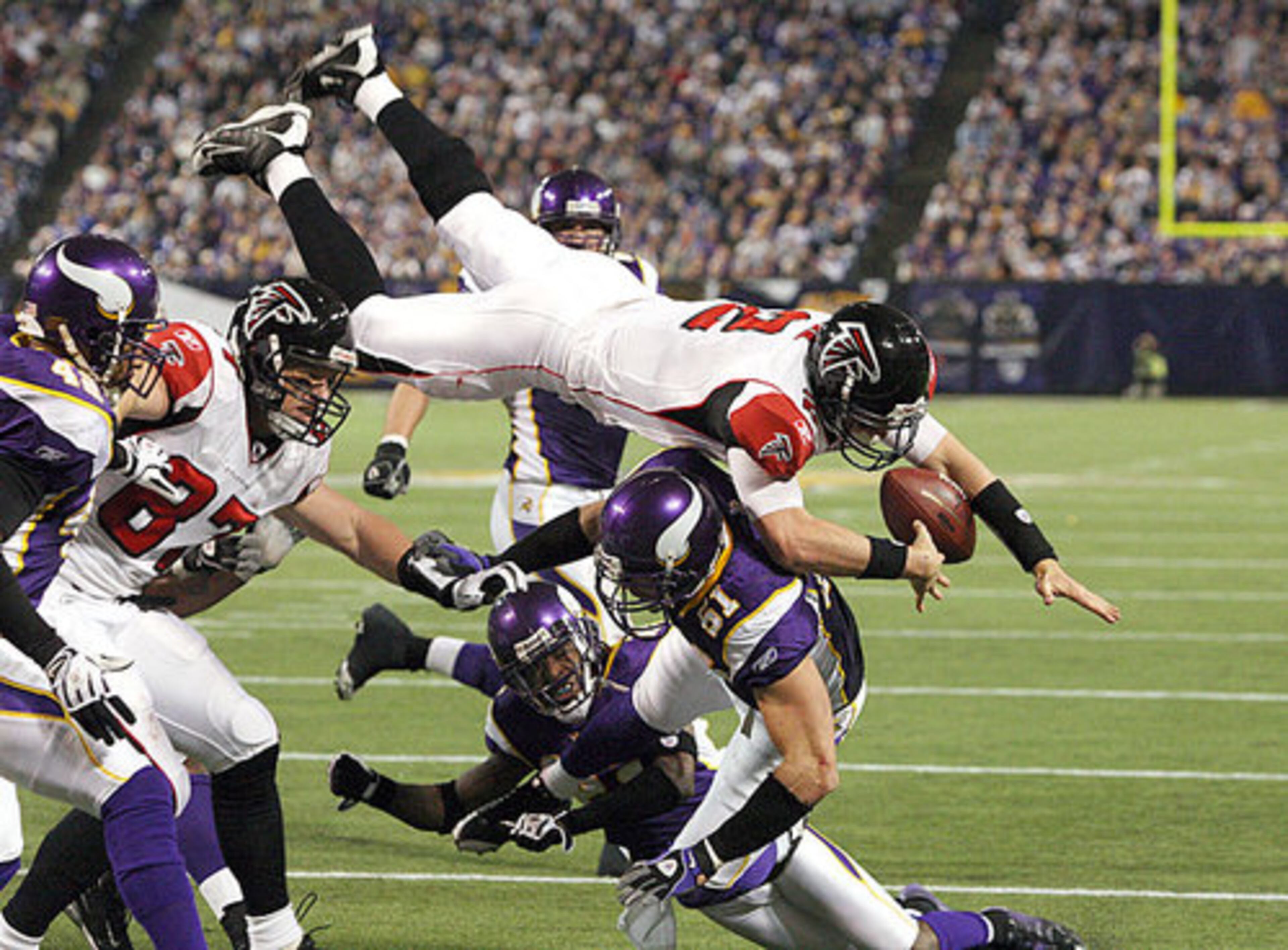 Falcons quarterback Matt Ryan (2) loses the ball as he leaps over Vikings linebacker Ben Leber (51) on a 4-yard scramble to the 1-yard line. The ball was recovered by Justin Blalock in the end zone for a Falcons score to extend Atlanta's lead by 21 in the third quarter.