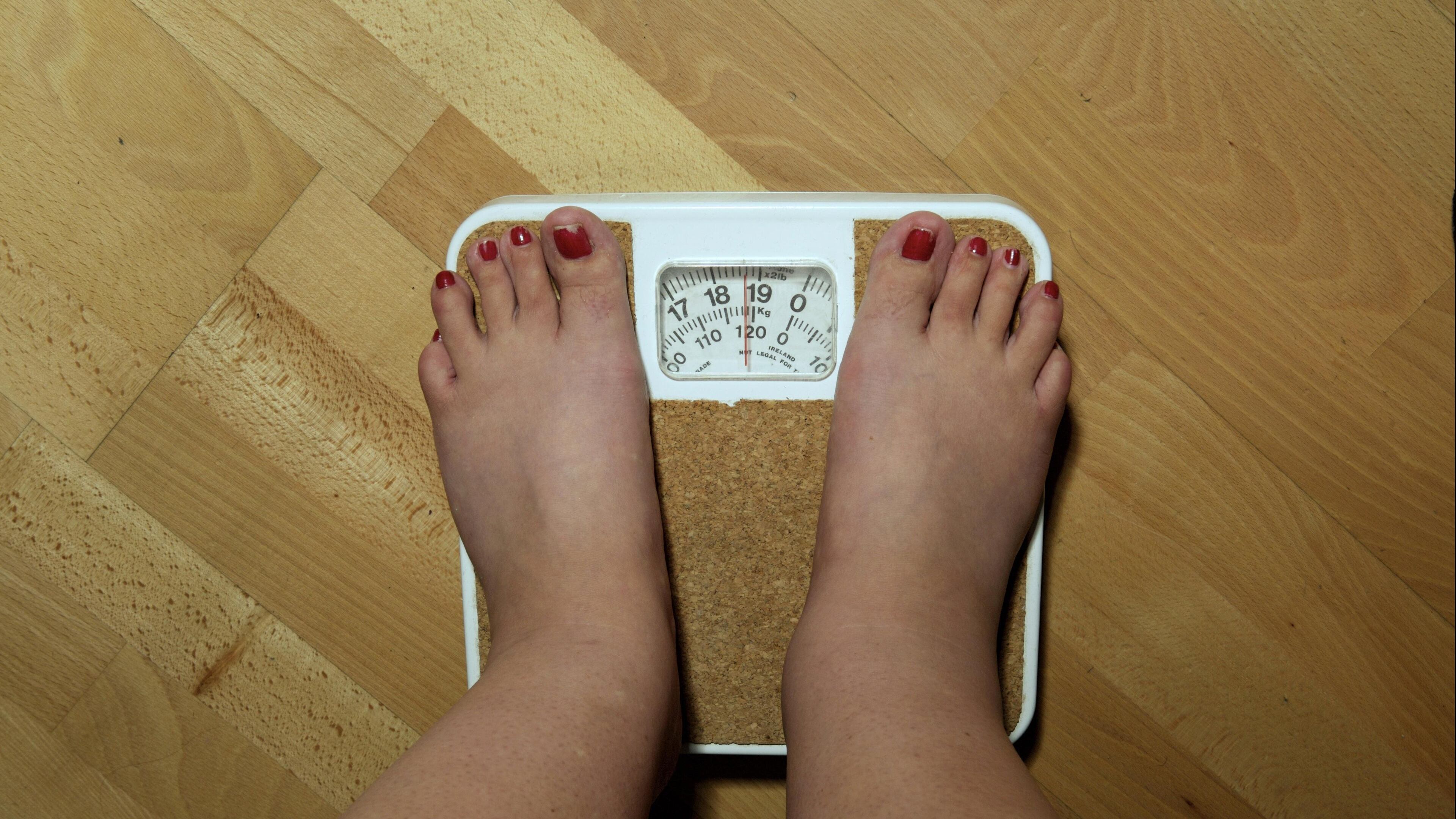 LONDON, ENGLAND - SEPTEMBER 2006: An anonymous woman, 42, on the scales before her weight loss surgery. The scales stop at 19 stone, but she weighs nearly 20 stone (126kg) and is severely obese. She hopes to lose around a third of her weight by having a gastric band fitted. (Photo by Tina Stallard/Getty Images)