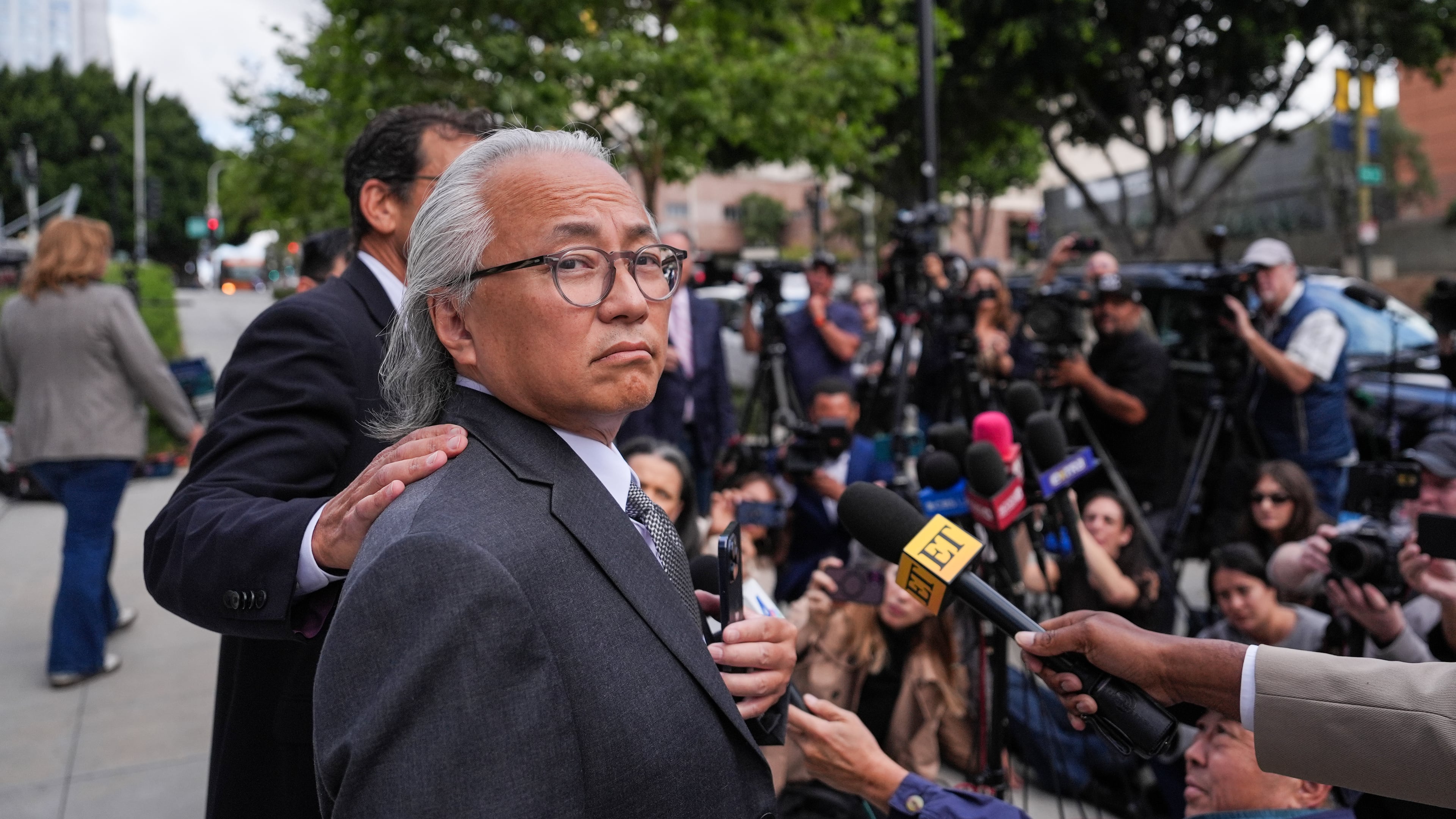 Kenneth Iwamasa, one of five people who pleaded guilty in the ketamine overdose death of actor Matthew Perry, looks away as his attorney, Alan Eisner, talks to reporters after Iwamasa's sentencing in Los Angeles, Wednesday, May 27, 2026. (AP Photo/Jae C. Hong)