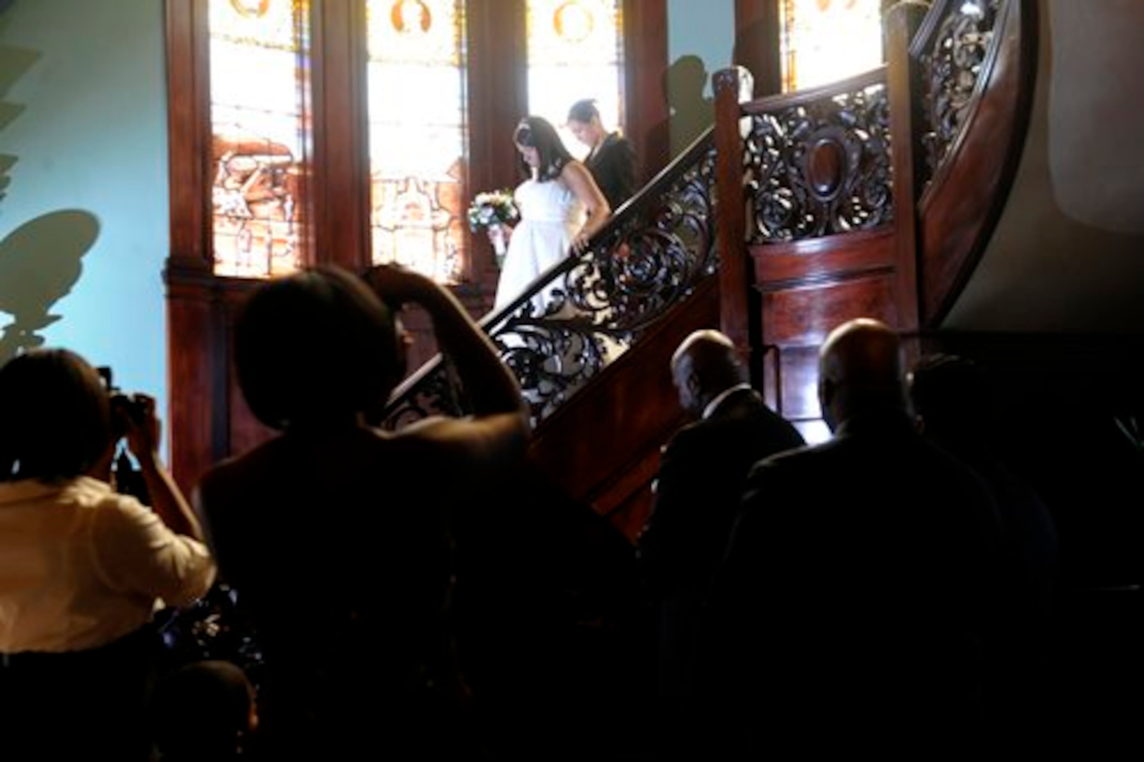 Sonnia Nunez walks down the grand staircase at Rhodes Hall on her way to exchange vows with Noel Khalil.