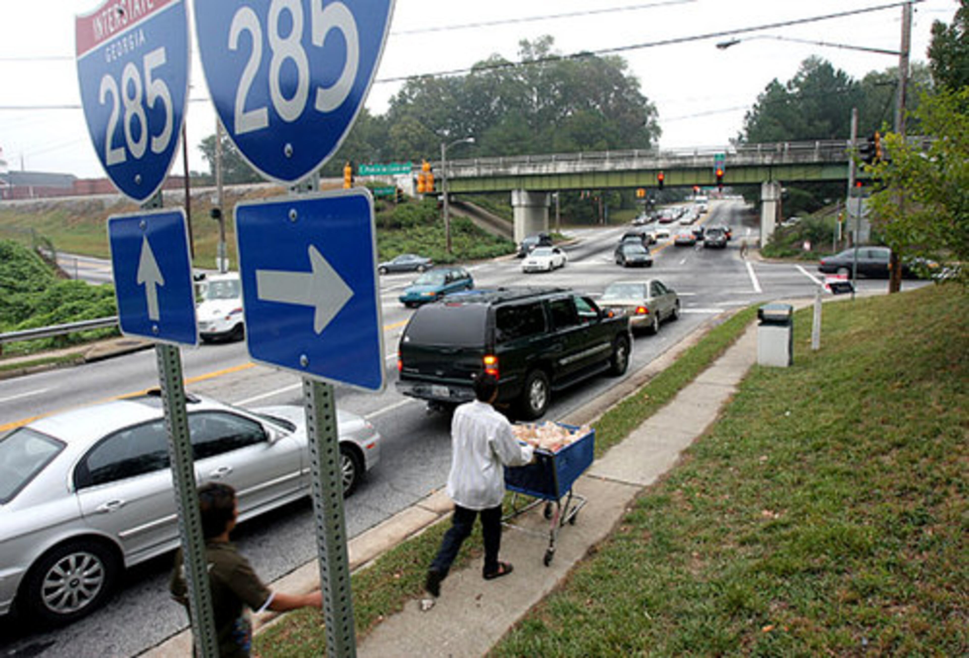 Than Chum pushes a cart of groceries back home after shopping with roommate Aung Lwin Nge Ni.