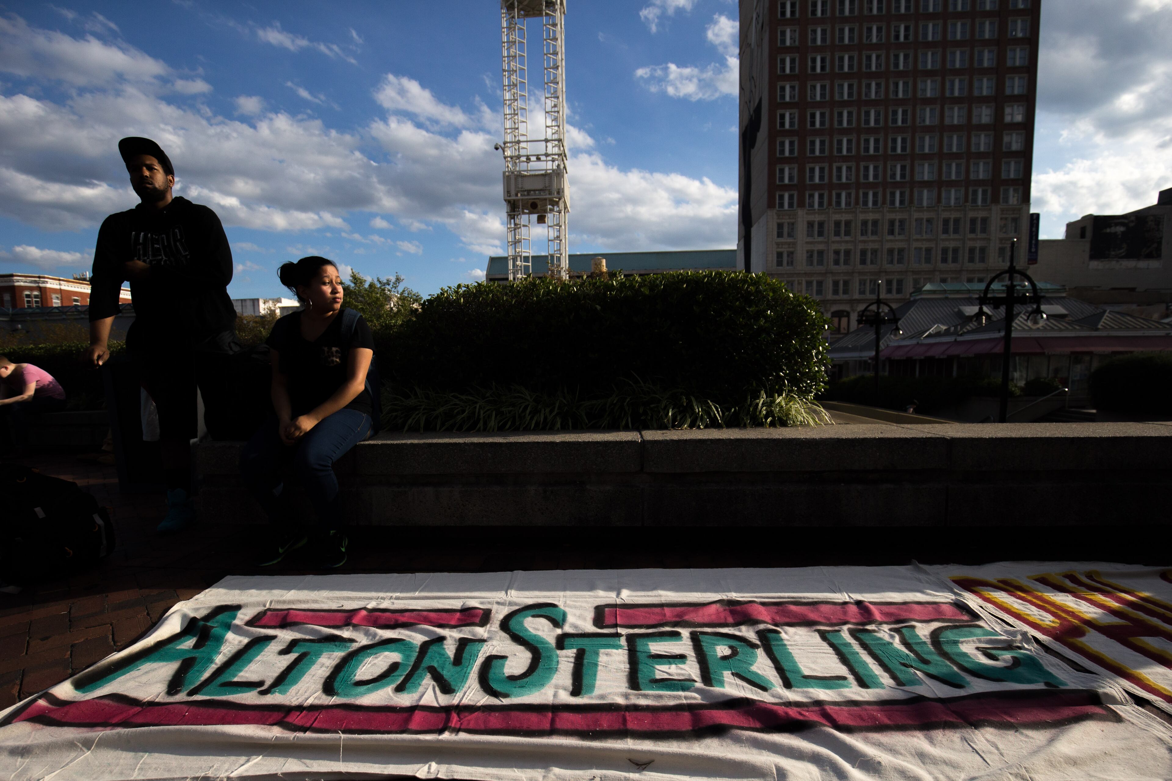 People sit before a rally at Underground Atlanta, Thursday, July 7, 2016, in Atlanta. Demonstrators gathered in response to the death of 37-year-old Alton Sterling, who was killed by Baton Rouge police outside of a convenience store where he was selling CDs and Philando Castile, who was shot and killed when Minnesota police stopped him for a traffic violation on Wednesday evening. BRANDEN CAMP/SPECIAL