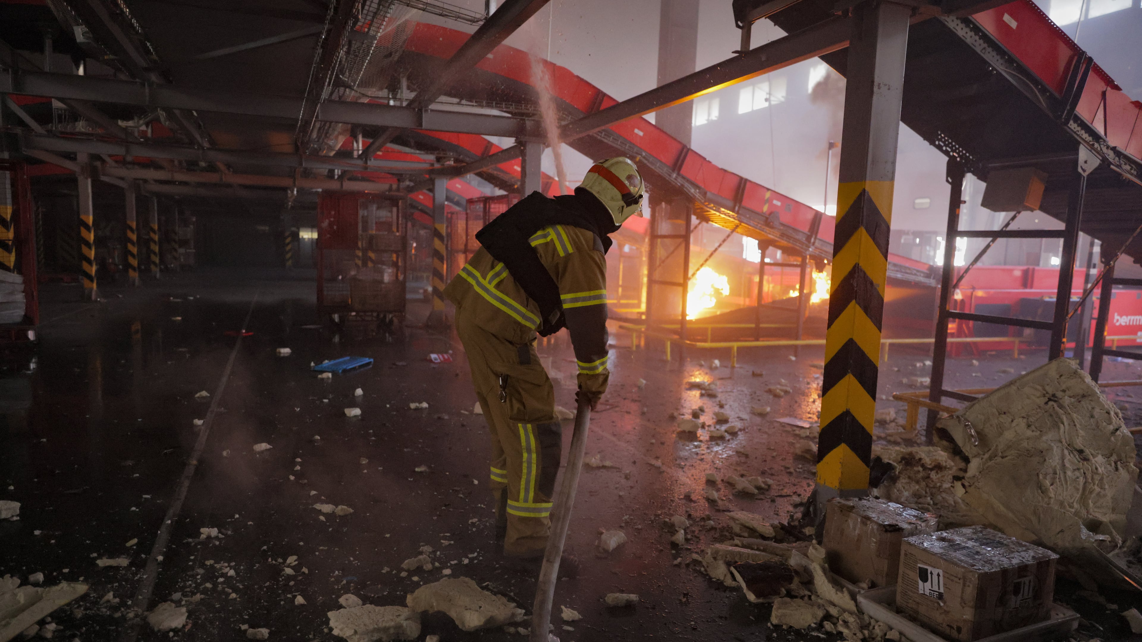 Firefighter put out a fire at a Nova Poshta postal warehouse following Russian air attack on the outskirts of Kharkiv, Ukraine, Sunday, Aug. 2, 2026. (AP Photo/Yevhen Titov)