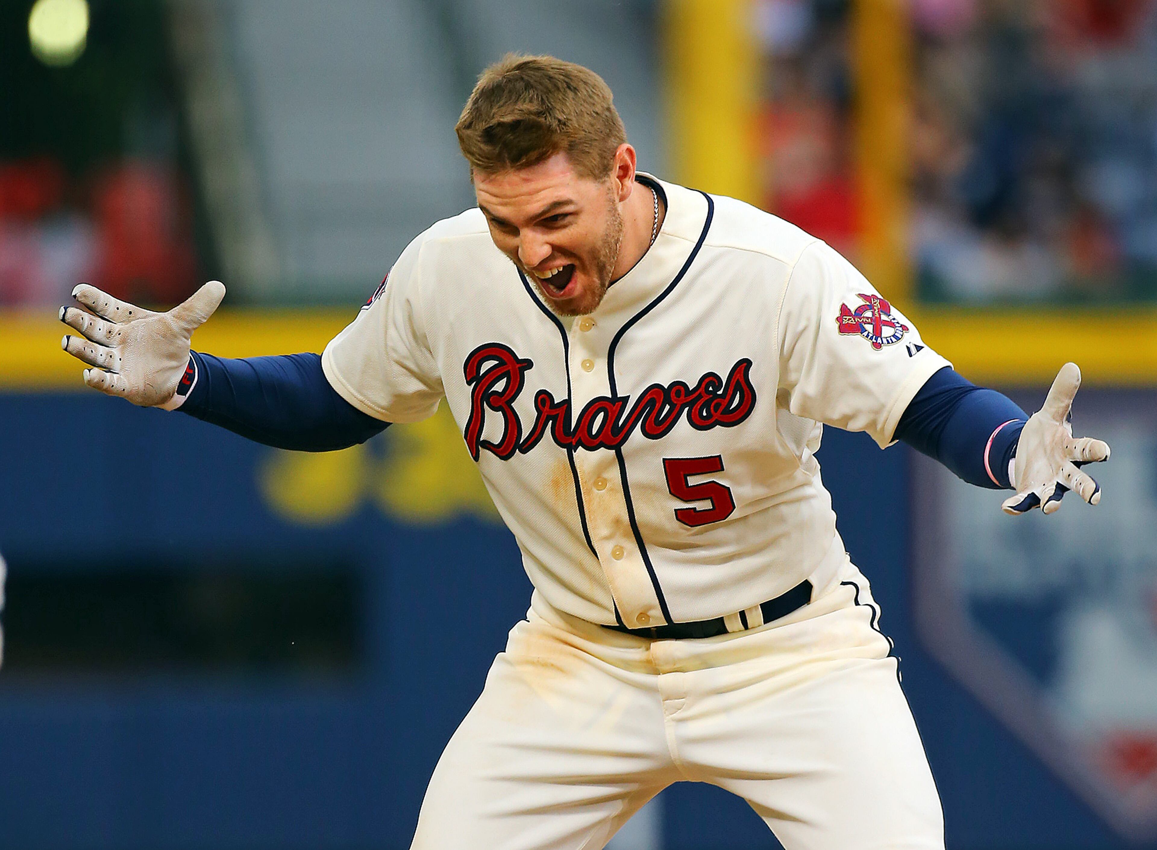 After rounding first base Freddie Freeman reacts to hitting the game-winning RBI single to beat the Reds 1-0 in the 10th inning of their MLB baseball game on Sunday, April 27, 2014, in Atlanta. CURTIS COMPTON / CCOMPTON@AJC.COM
