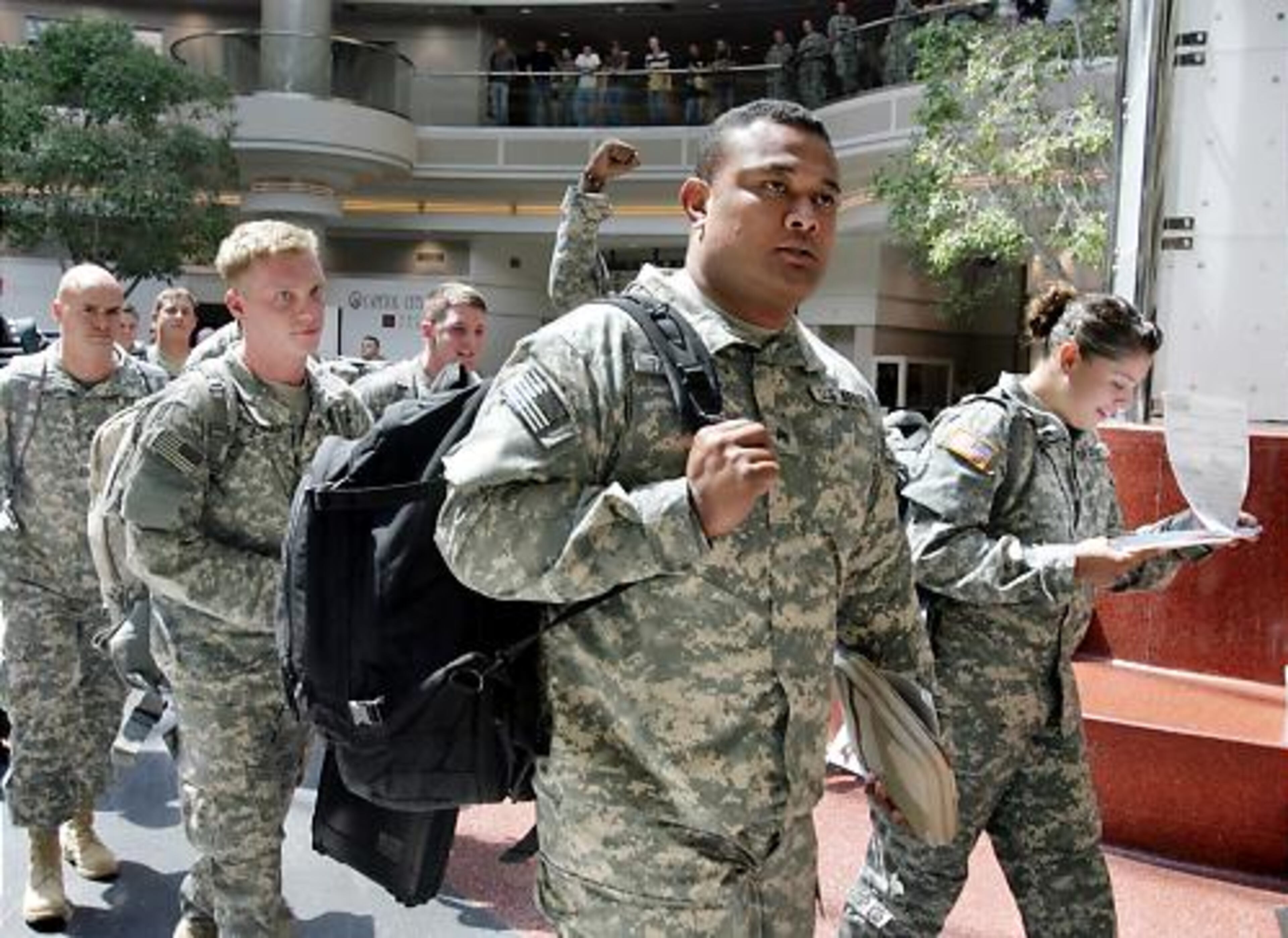 Soldiers on their way to Iraq walk through the airport to the sound of applause.