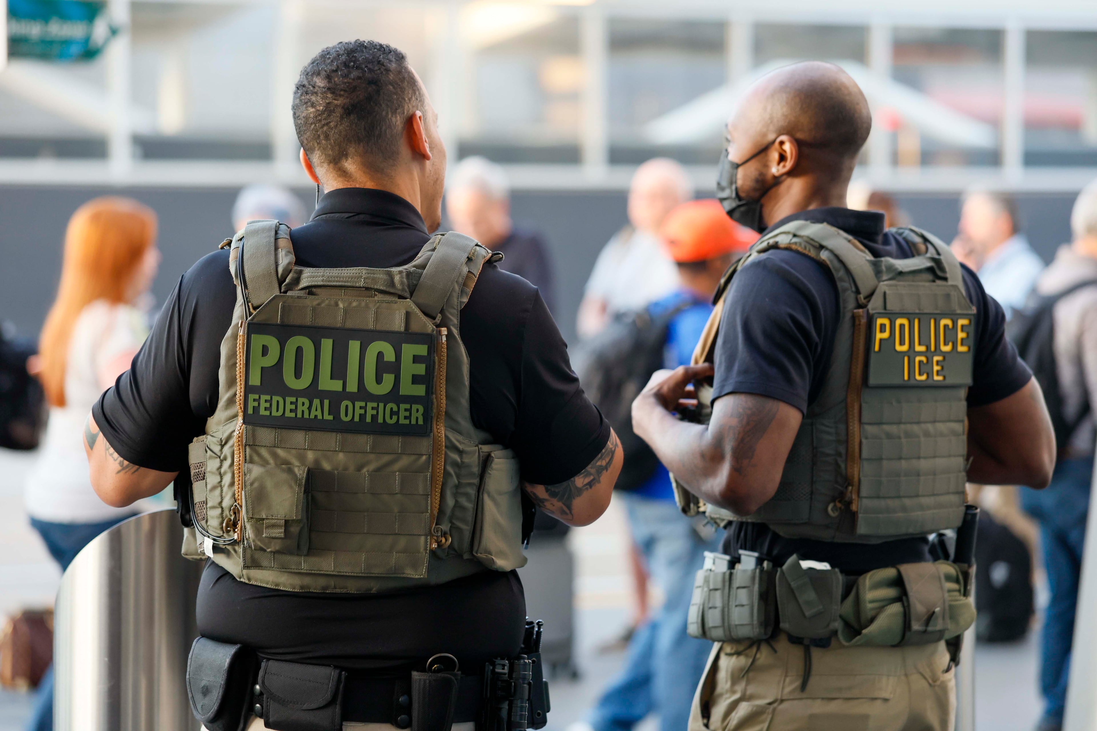 Federal ICE agents monitor sidewalk activity while supporting TSA operations as travelers queue for security at Hartsfield-Jackson Atlanta International Airport on Monday, March 23, 2026. ICE agents will not perform immigration enforcement during this deployment, according to Atlanta Mayor Andre Dickens.
(Miguel Martinez/AJC)