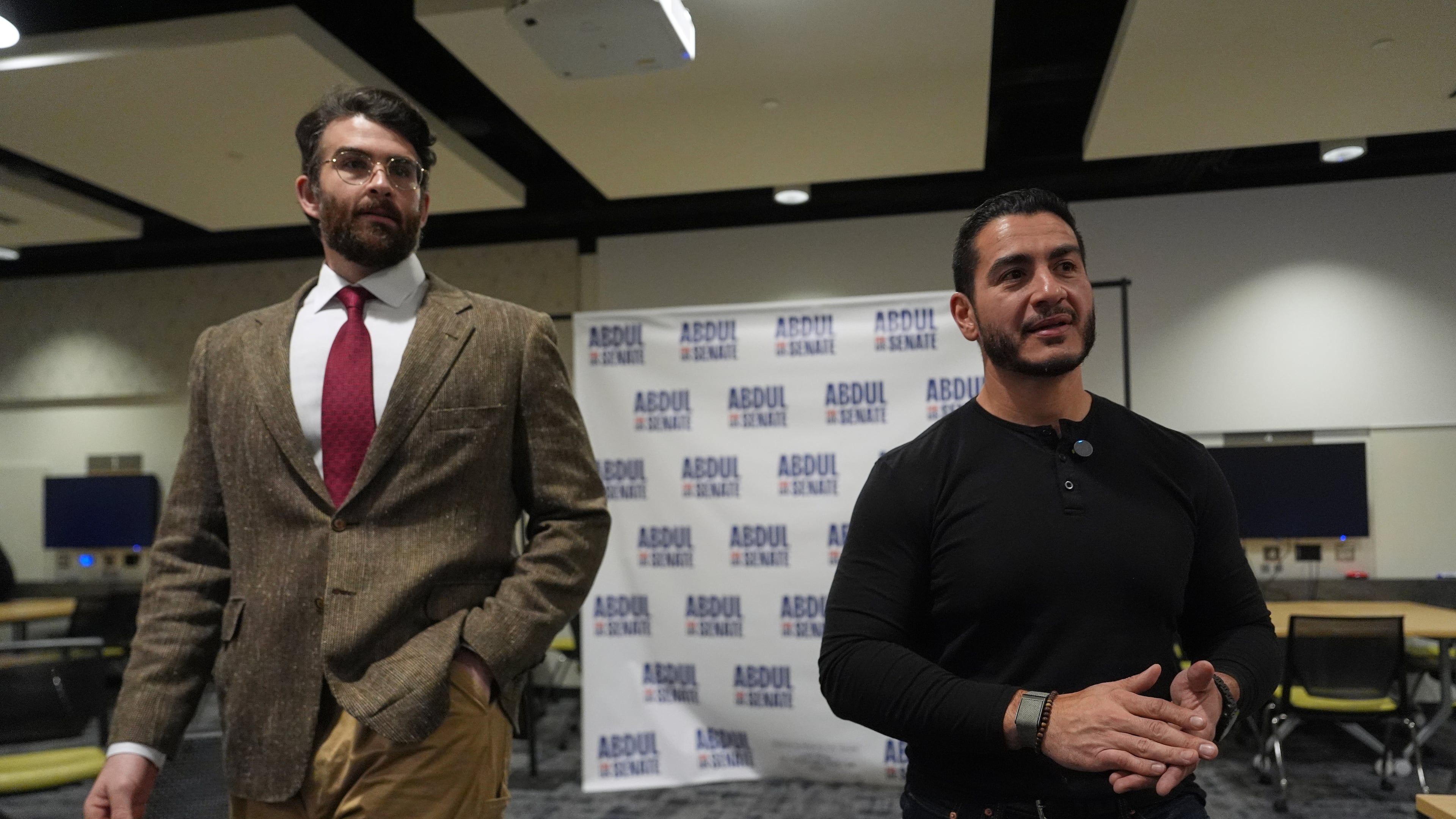Hasan Piker, left, listens as Abdul El-Sayed, a progressive candidate in the Democratic primary for U.S. Senate in Michigan, speaks in a green room before a campaign rally, Tuesday, April 7, 2026, at the University of Michigan in Ann Arbor, Mich. (AP Photo/Julia Demaree Nikhinson)