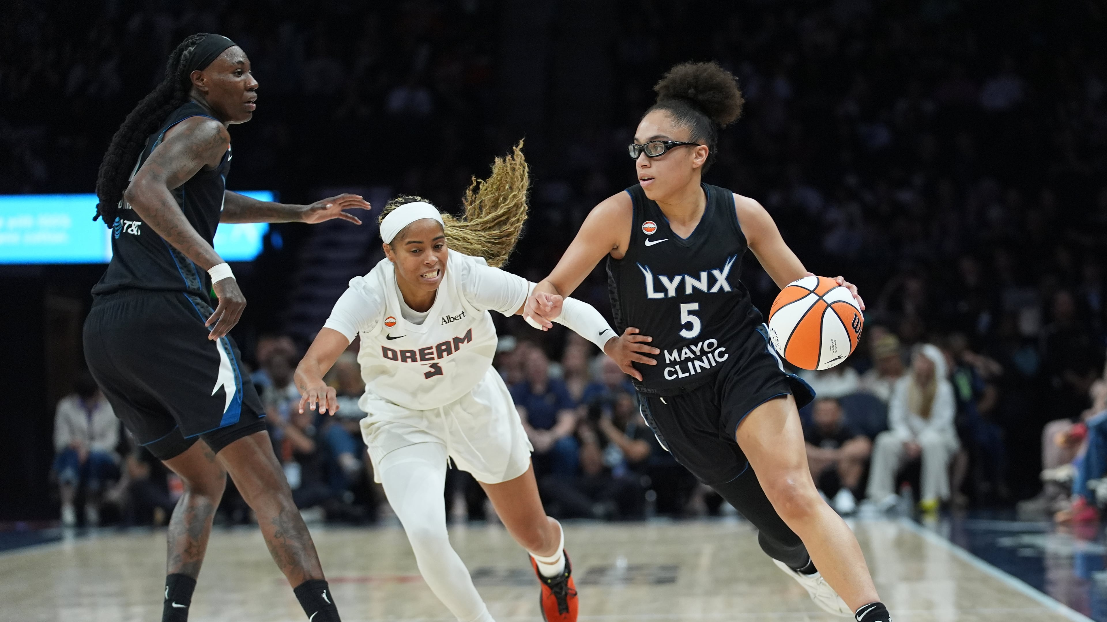 Minnesota Lynx guard Olivia Miles (5) works toward the basket while defended by Atlanta Dream guard Jordin Canada (3) during the first half of a WNBA basketball game Wednesday, May 27, 2026, in Minneapolis. (AP Photo/Abbie Parr)