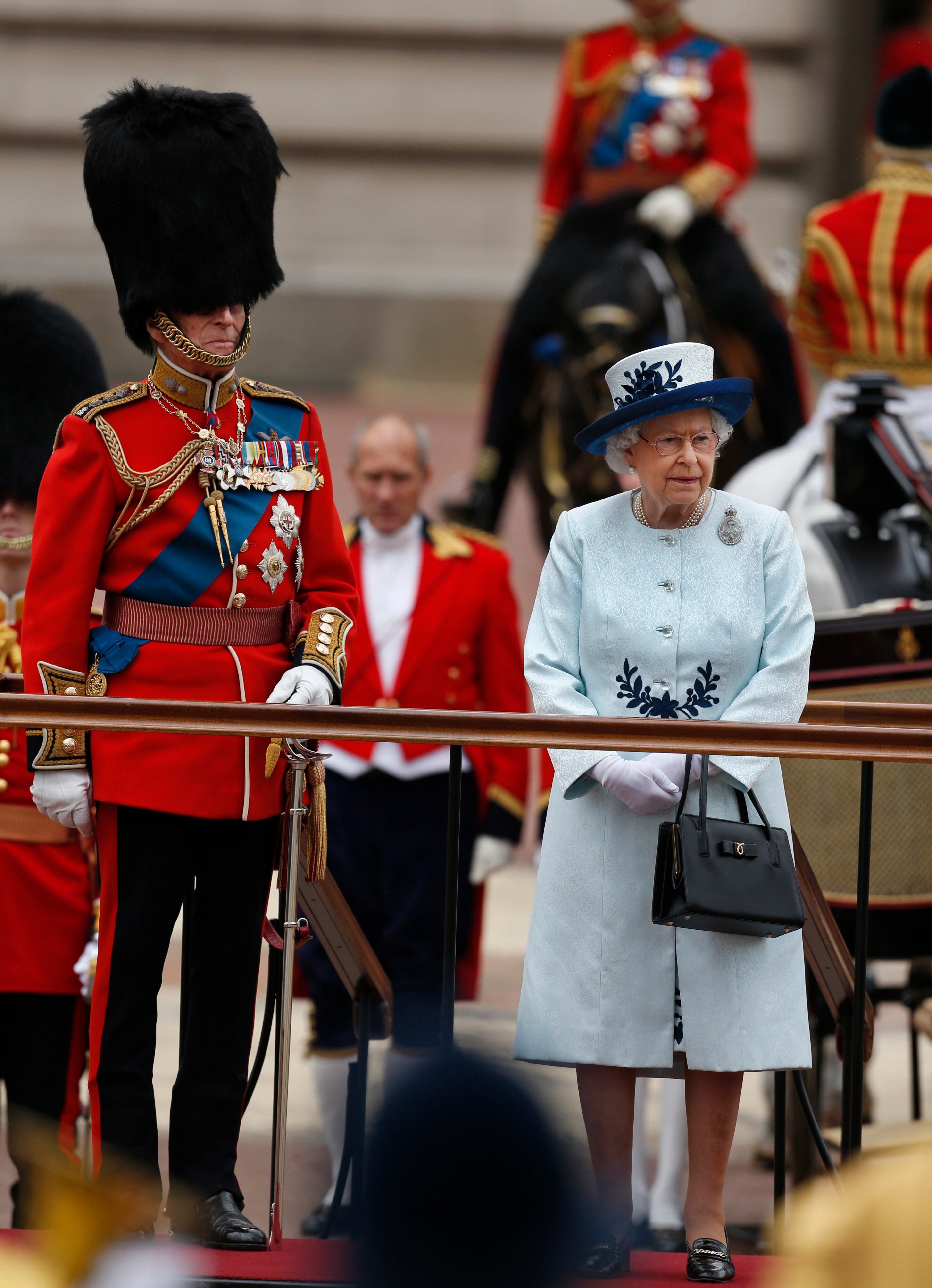 Britain's Queen Elizabeth II, along with Prince Philip, reviews parading troops during the Trooping The Colour parade, outside Buckingham Palace in central London, Saturday, June 14, 2014. (AP Photo/Lefteris Pitarakis)