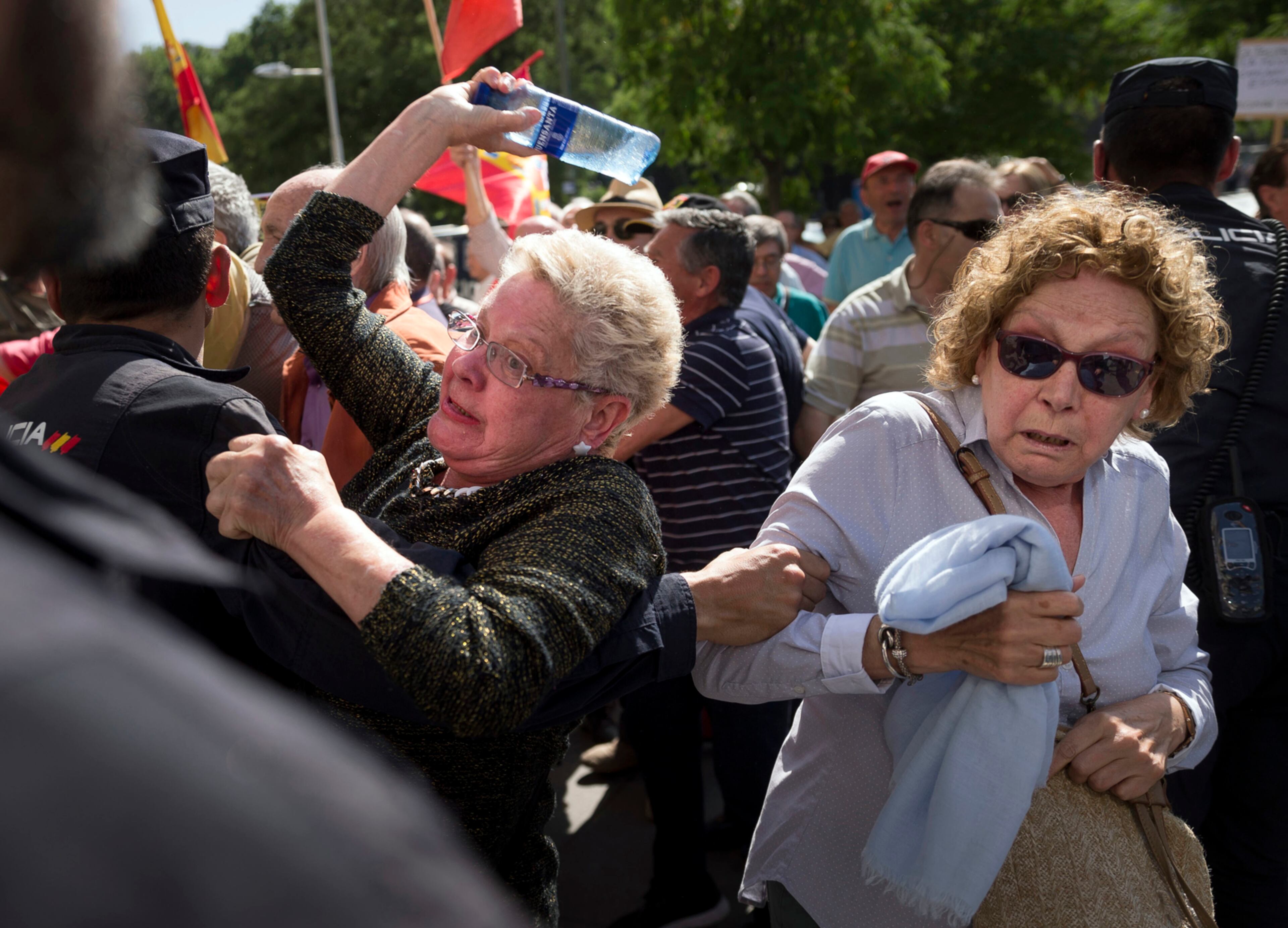 A protester throws a bottle of water at a Catalan politician arriving to the Madrid town hall during a protest against Catalan independence in Madrid, Spain, Monday, May 22, 2017. Spanish Prime Minister Mariano Rajoy on Monday accused Catalan President Carles Puigdemont of blackmailing the state following news reports that the powerful northeastern region has prepared a law to secede from Spain immediately if it is not allowed hold an independence referendum.(AP Photo/Daniel Ochoa de Olza)