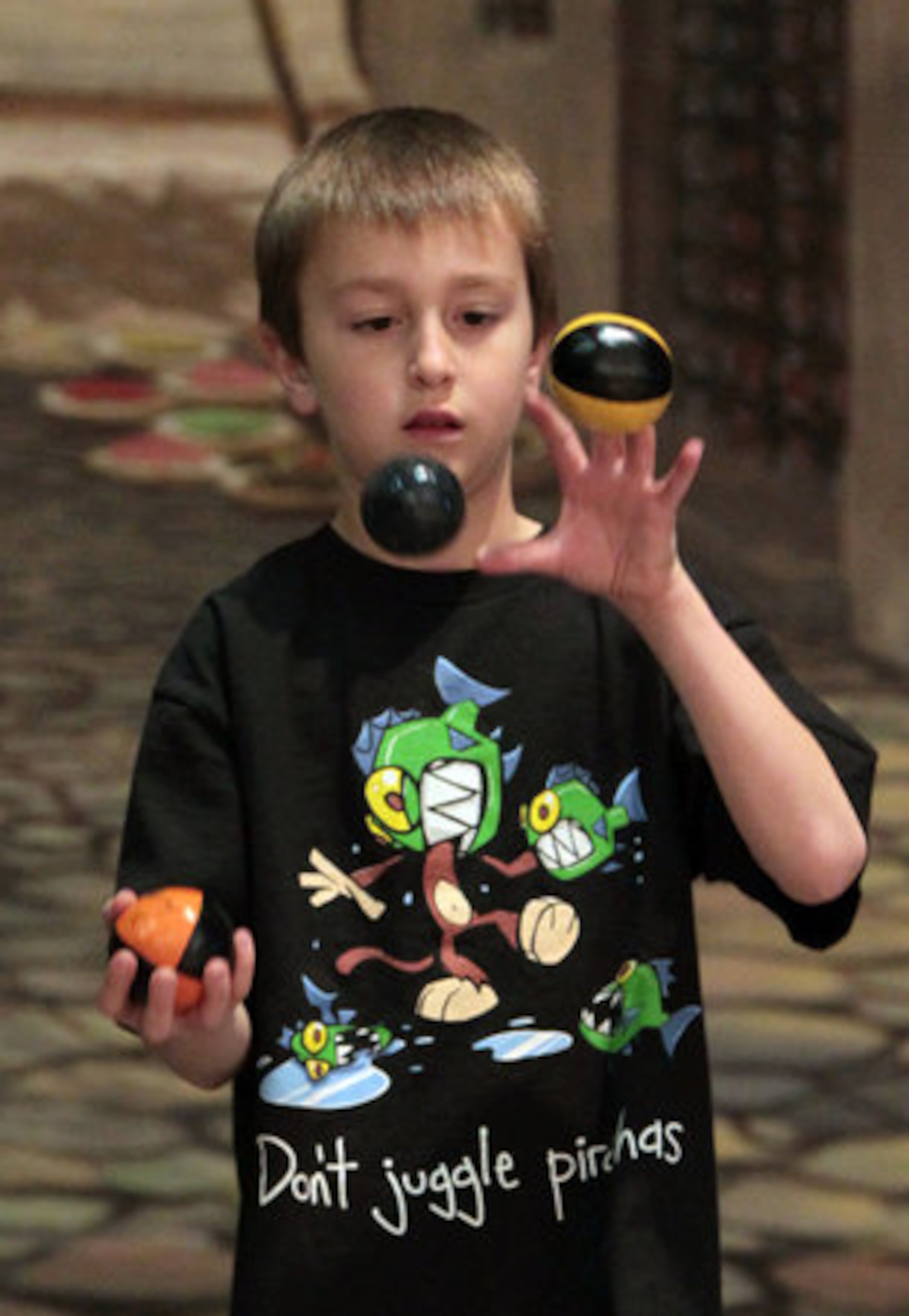 Ian Willoughby, 8, of Ocala, Fla., practices his juggling skills as he wears a shirt reading, "Don't juggle piranhas," during the 33rd Annual Groundhog Day Jugglers Festival. Willoughby has been juggling for two years and was to compete later Saturday.