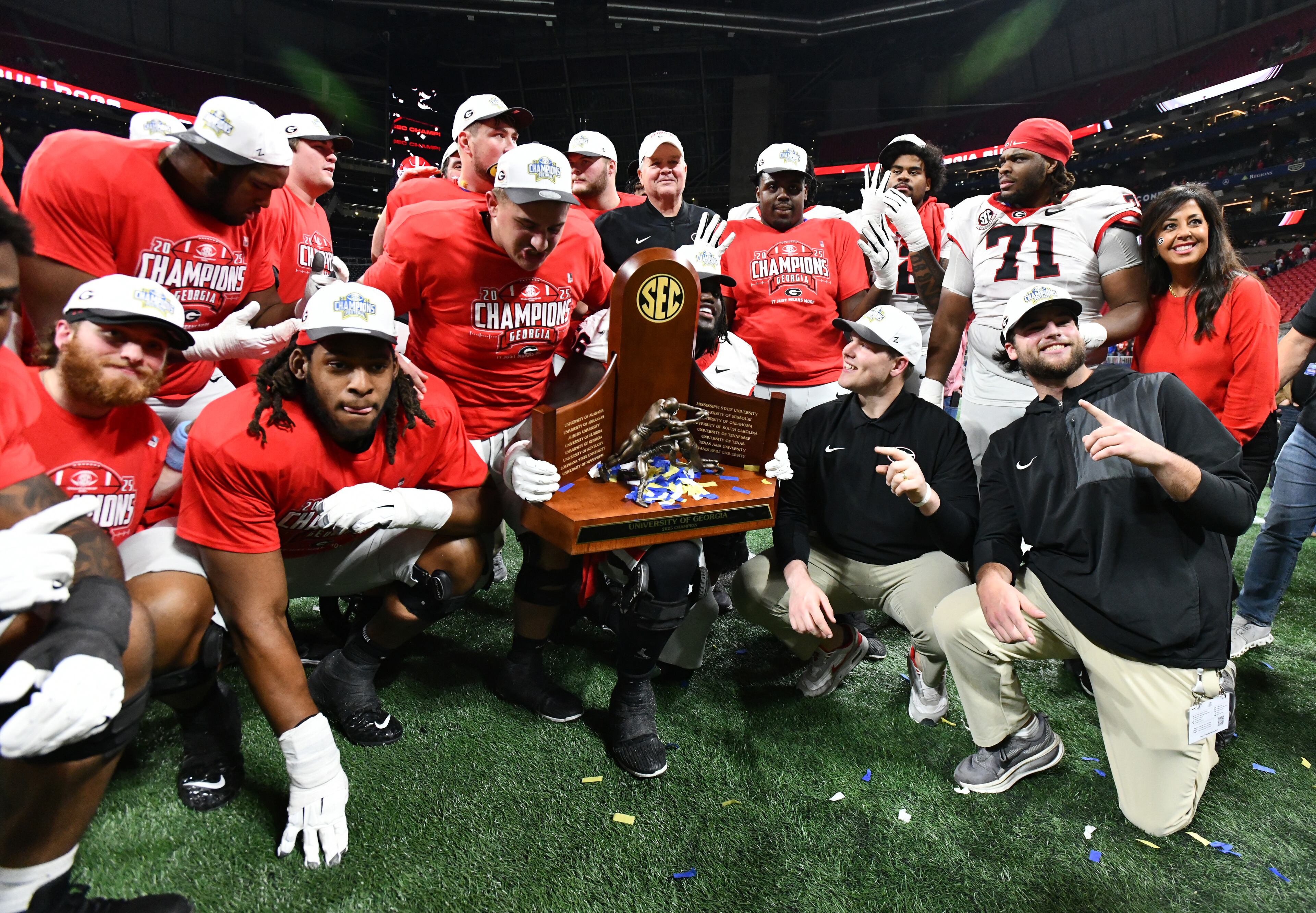 Georgia offensive lineman pose with the championship trophy as they celebrate after defeating Alabama 28-7 in the SEC Championship football game at the Mercedes-Benz Stadium, Saturday, Dec. 6, 2025 in Atlanta. (Hyosub Shin / AJC)