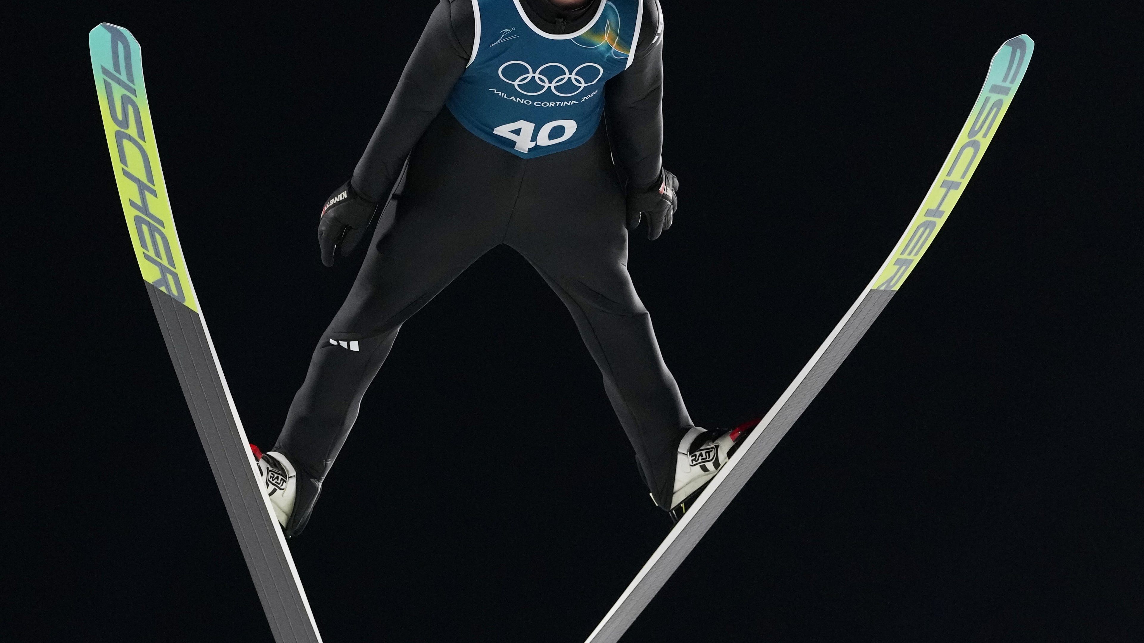 An athlete soars through the air during a ski jumping, men's normal hill, training session,at the 2026 Winter Olympics, in Predazzo, Italy, Thursday, Feb. 5, 2026. (AP Photo/Kirsty Wigglesworth)