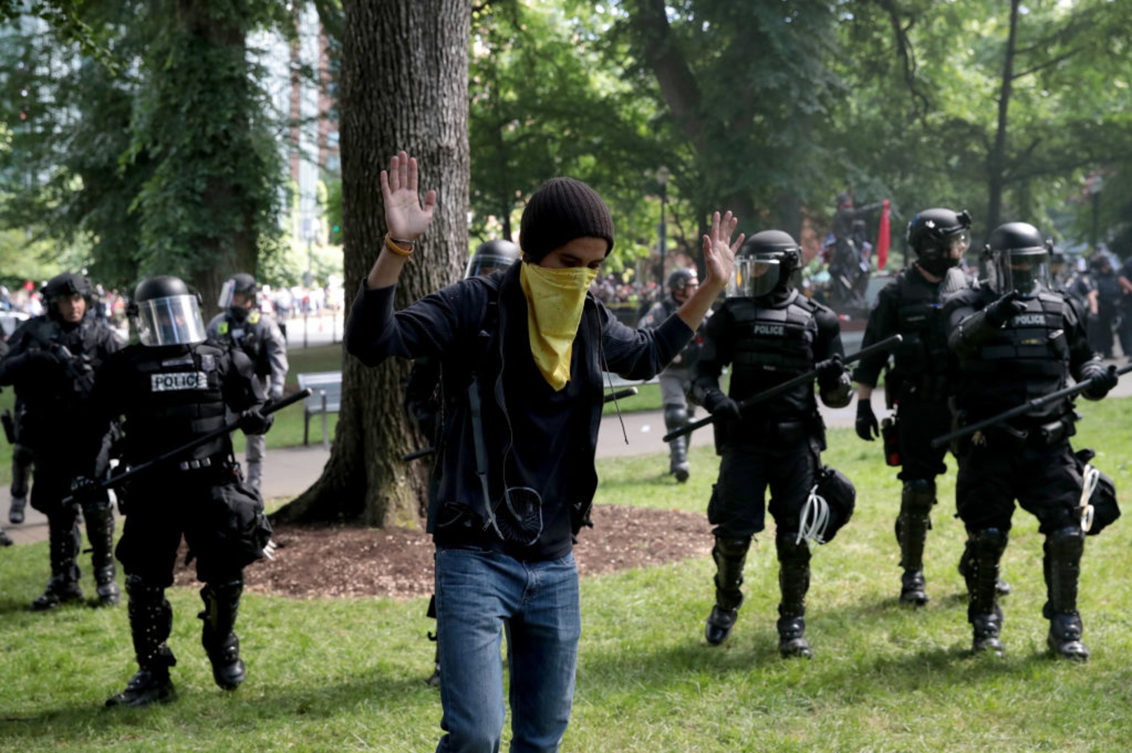 PORTLAND, OR - JUNE 04: A man raises his hands as police clash with demonstrators as they try to clear 'Antifa' members and anti-Trump protesters from the area during a protest on June 4, 2017 in Portland, Oregon. Police used tear gas, flash bangs, and rubber bullets to clear the crowd. A protest dubbed "Trump Free Speech" by organizers was met by a large contingent of counter-demonstrators who viewed the protest as a promotion of racism. The demonstrations come in the wake of the recent violent attack on the city's MAX train line when Ricky Best, 53, and Taliesin Namkai-Meche, 23, were stabbed to death and Micah Fletcher,21, was severely injured after they tried to protect two teenage girls, one of whom was wearing a hijab, from being harassed with racial taunts by suspect Jeremy Christian. (Photo by Scott Olson/Getty Images)