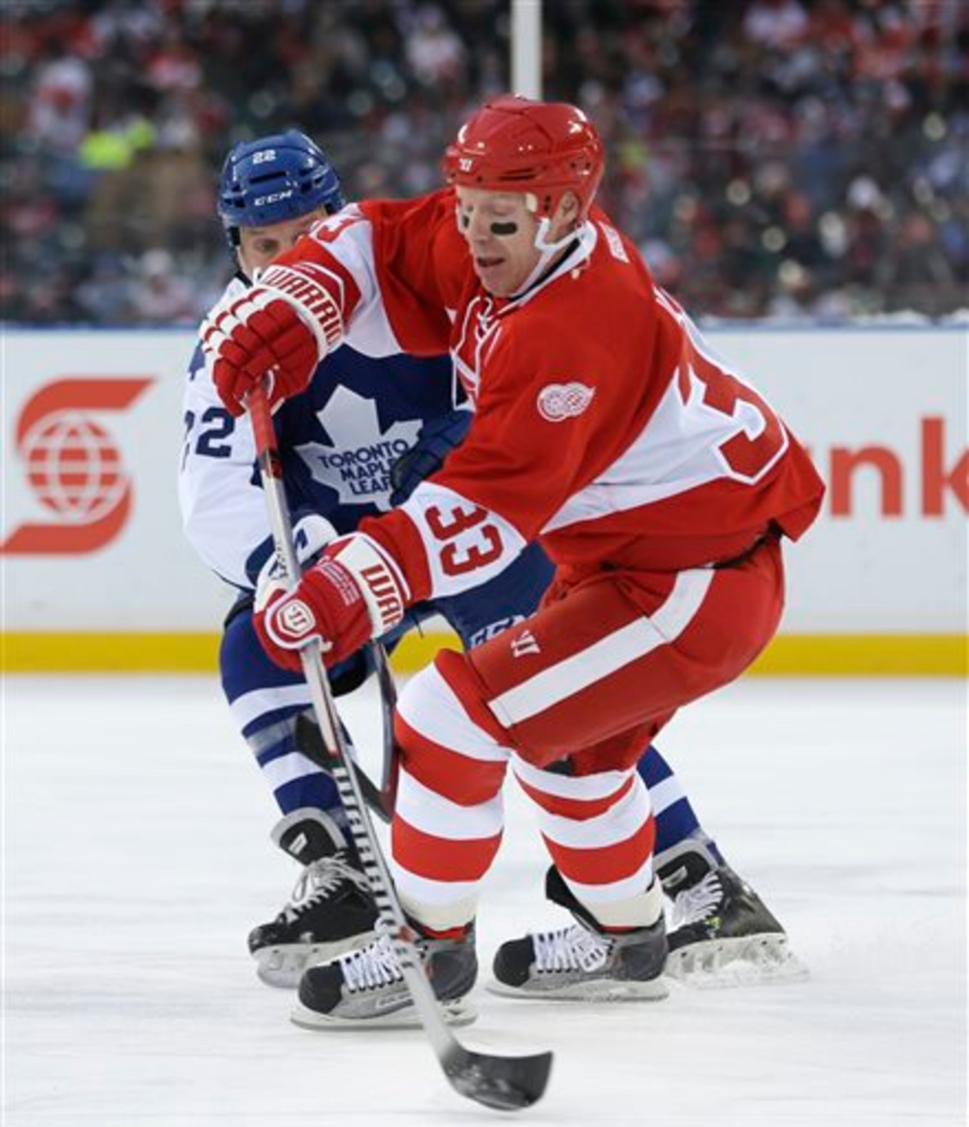 Detroit Red Wings forward Kris Draper controls the puck as Toronto Maple Leafs' Mike Gartner defends during the first period of the Winter Classic Alumni outdoor NHL hockey game at Comerica Park in Detroit, Tuesday, Dec. 31, 2013. (AP Photo/Carlos Osorio)