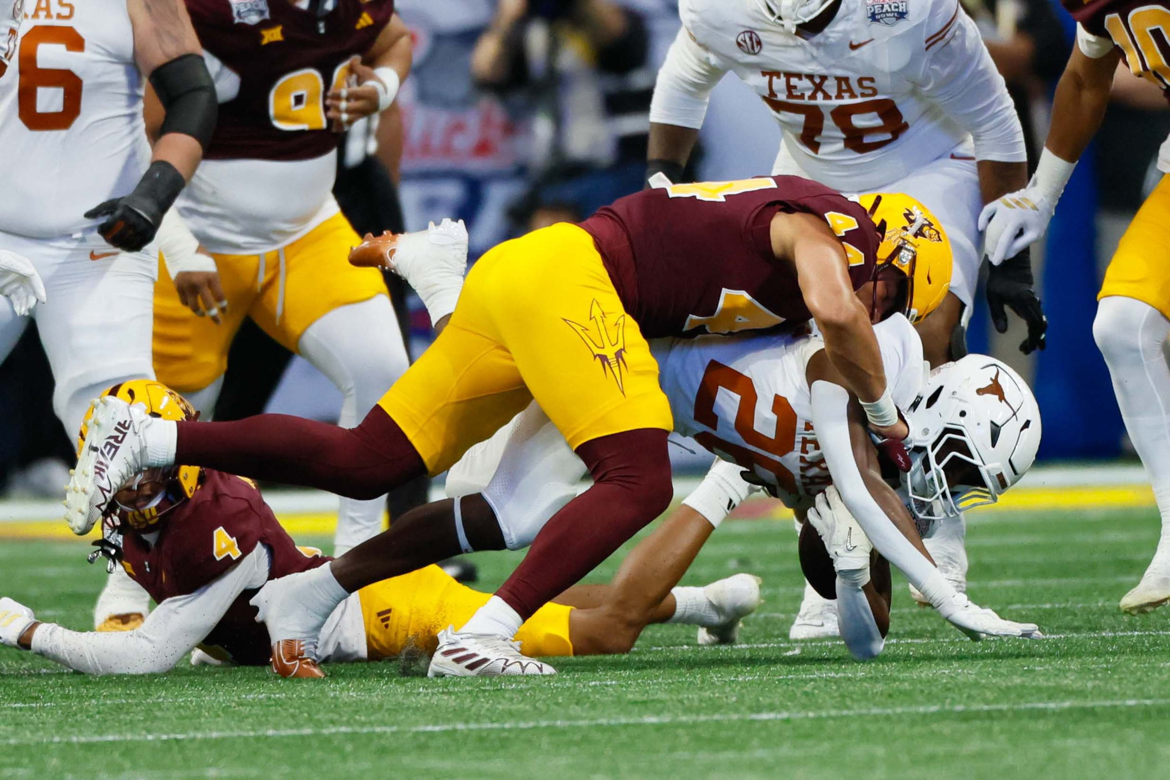 Texas Longhorns running back Quintrevion Wisner (26) gets tackled by Arizona State Sun Devils defensive back Myles Rowser (4) during the first half in the 2024 Chick-fil-A Peach Bowl at Mercedes-Benz Stadium, Wednesday, January 1, 2025, in Atlanta.
(Miguel Martinez / AJC)