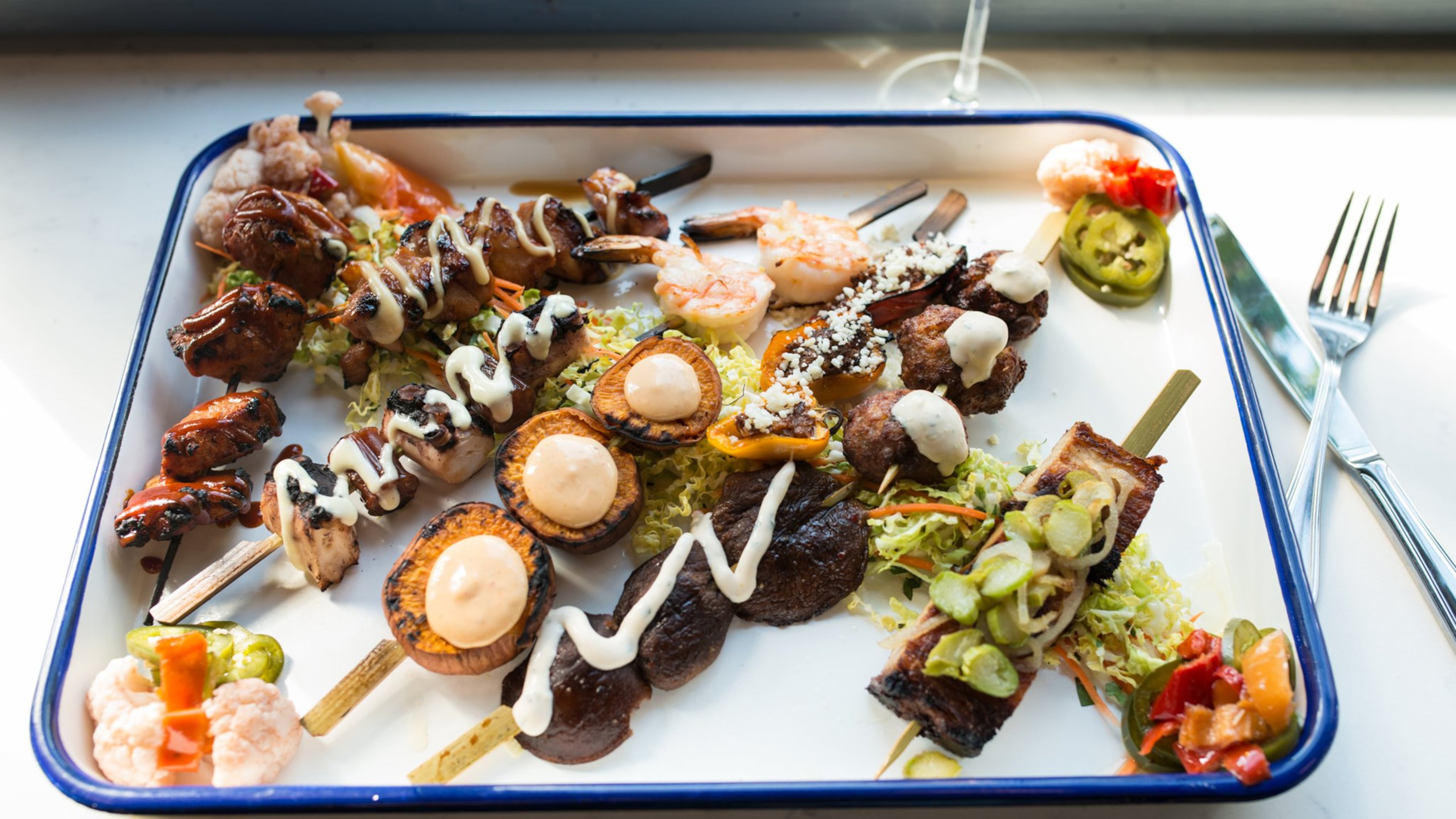 Whiskey Bird yakitori skewers with sticky soy chicken, crispy meatball, pork belly, charred octopus, sweet potato, shitake mushroom, and stuffed peppers. Photo credit- Mia Yakel.