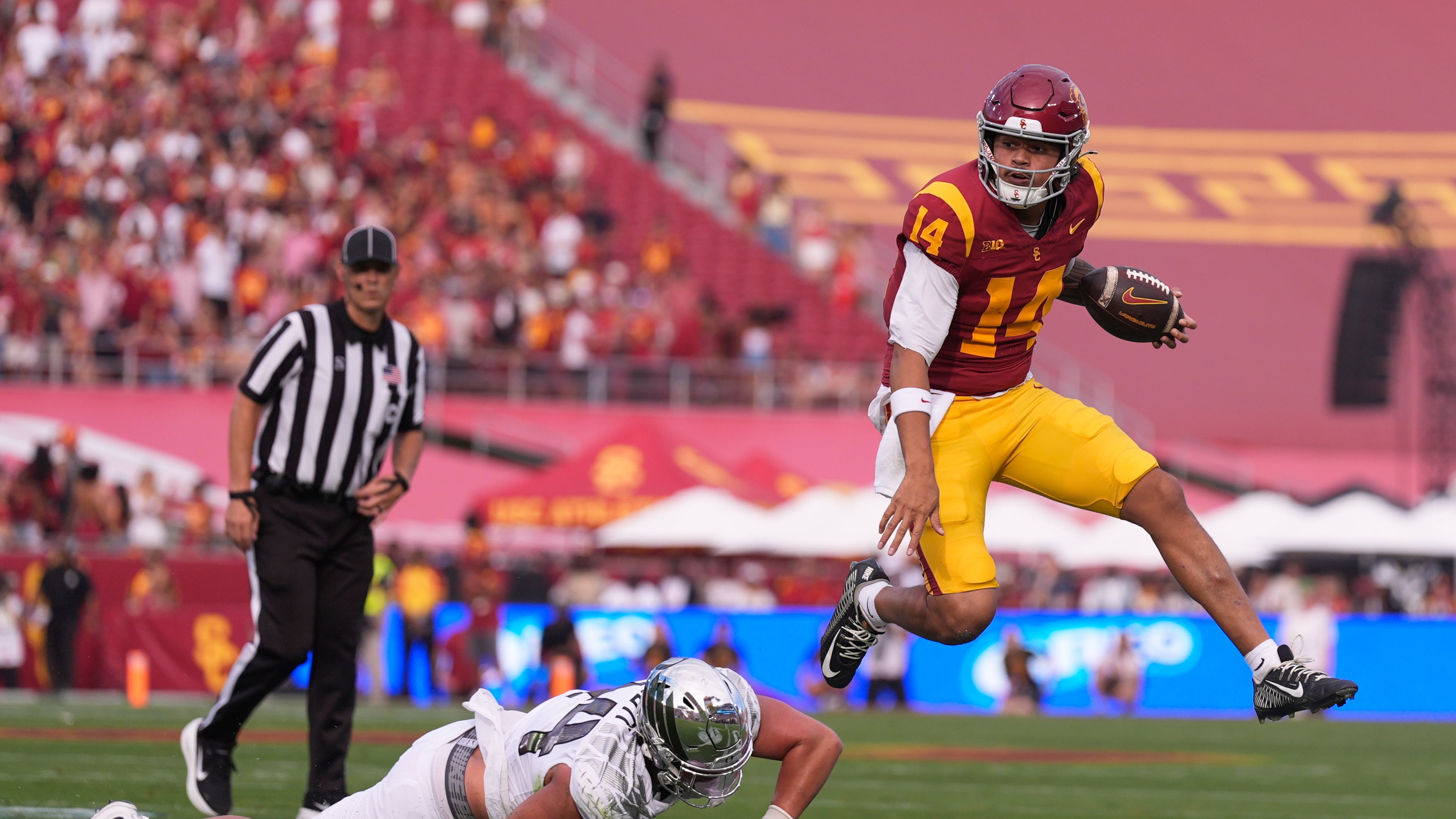Southern California quarterback Jayden Maiava, right, jumps away from Oregon linebacker Teitum Tuioti during the first half of an NCAA college football game, Saturday, Sept. 26, 2026, in Los Angeles. (AP Photo/Mark J. Terrill)