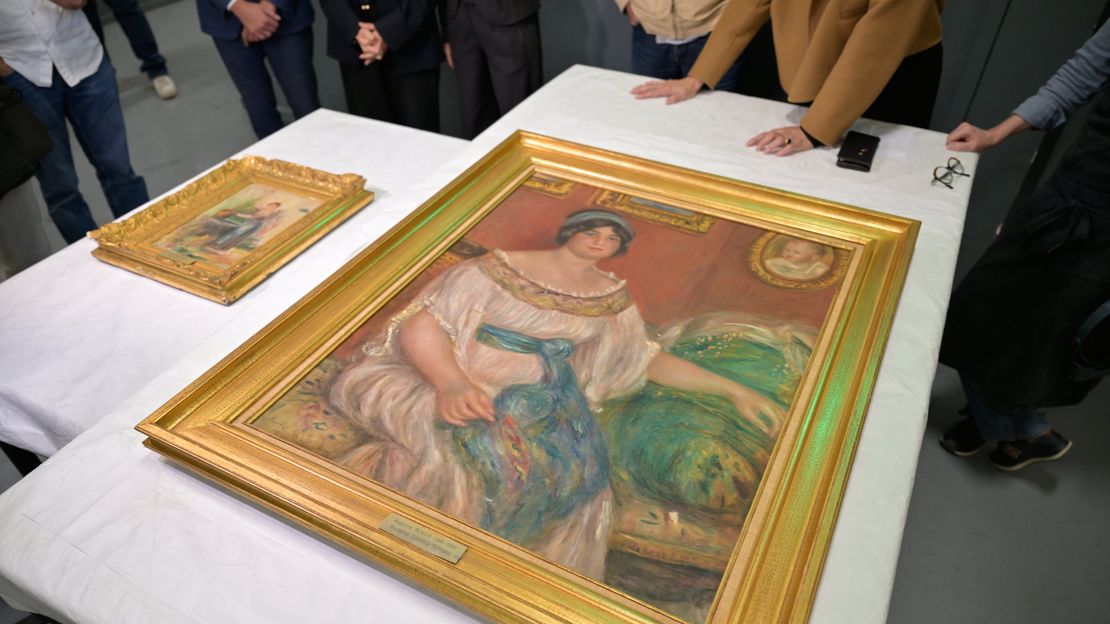Recovered paintings "Portrait of Madame Colonna Romano", right, and "Young Woman at the Well," stolen from the Renoir Museum in Cagnes-sur-Mer are on display at the Interdisciplinary Centre for the Conservation and Restoration of Heritage in Marseille, France, Monday Oct. 12, 2026. (AP Photo/Philippe Magoni)