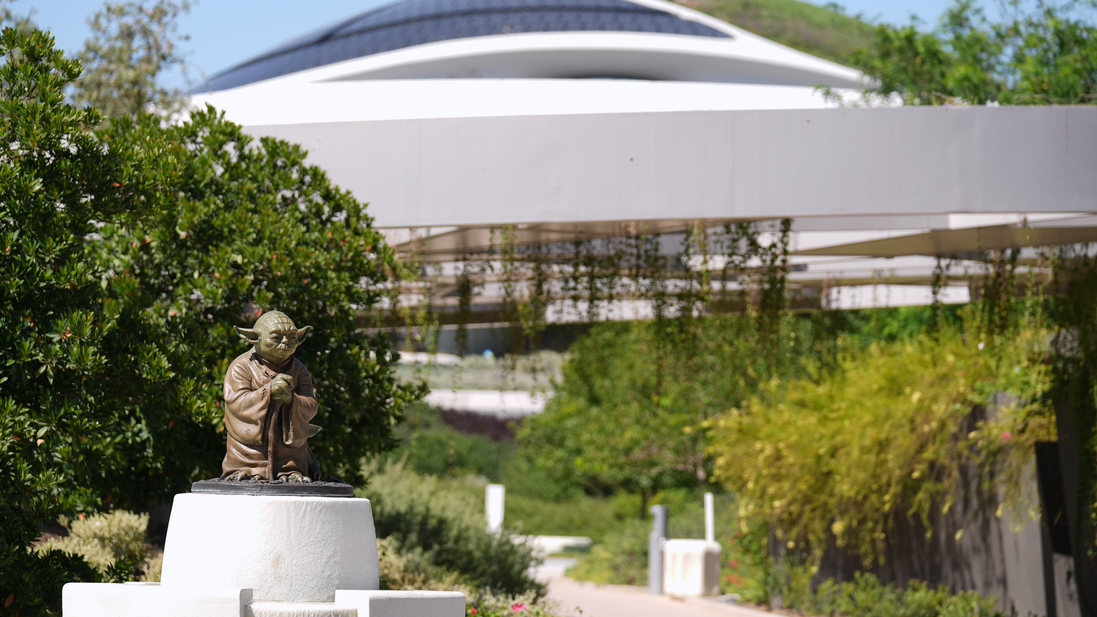 A sculpture of the "Star Wars" character Yoda is displayed along a walking path in the garden area of the the Lucas Museum of Narrative Art during a preview of the museum on Monday, Aug. 31, 2026, in Los Angeles. (AP Photo/Chris Pizzello)