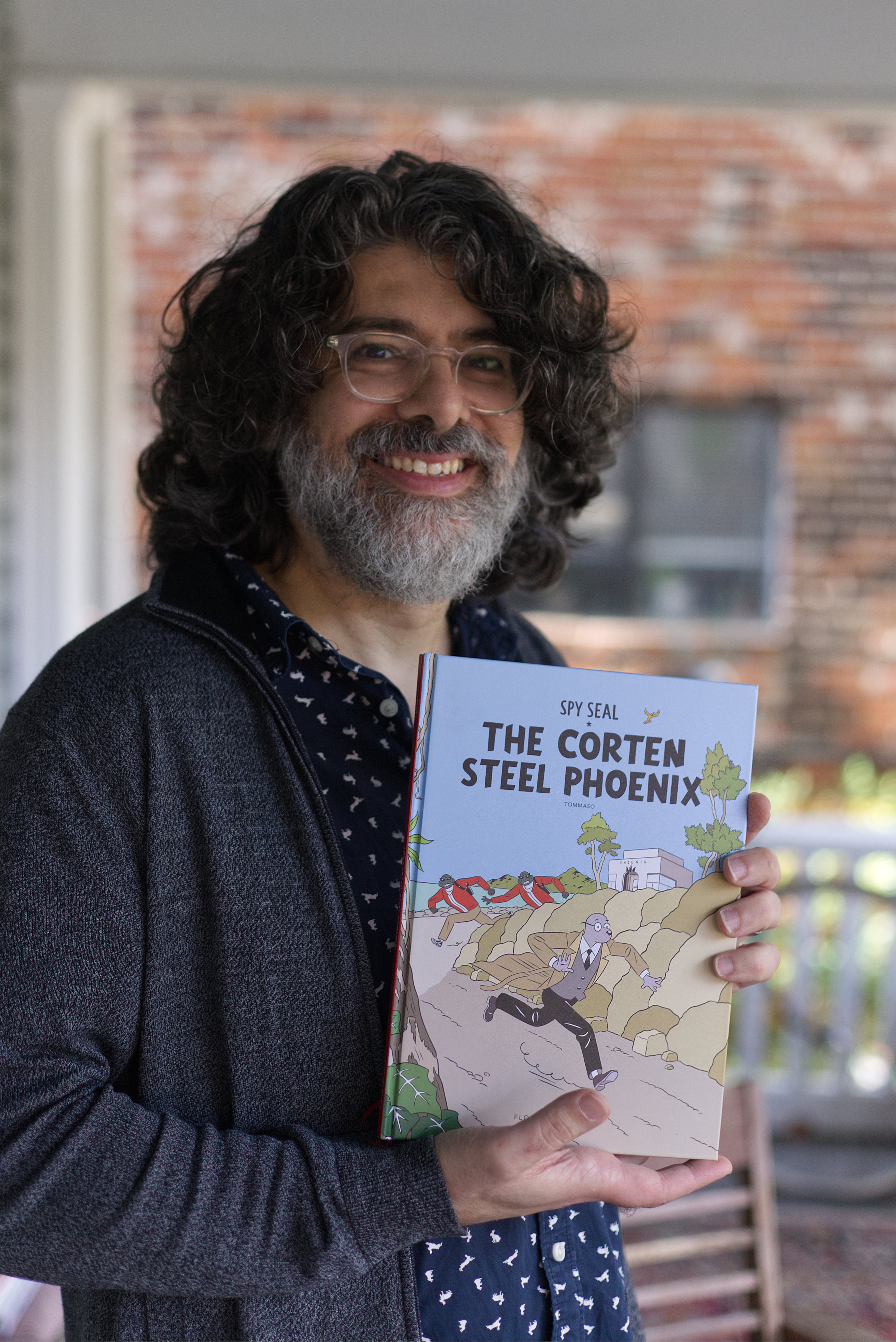 Tommaso poses with a copy of his recently expanded and reissued "Spy Seal: The Corten Steel Phoenix." (Dustin Timbrook/Courtesy of Arts ATL)