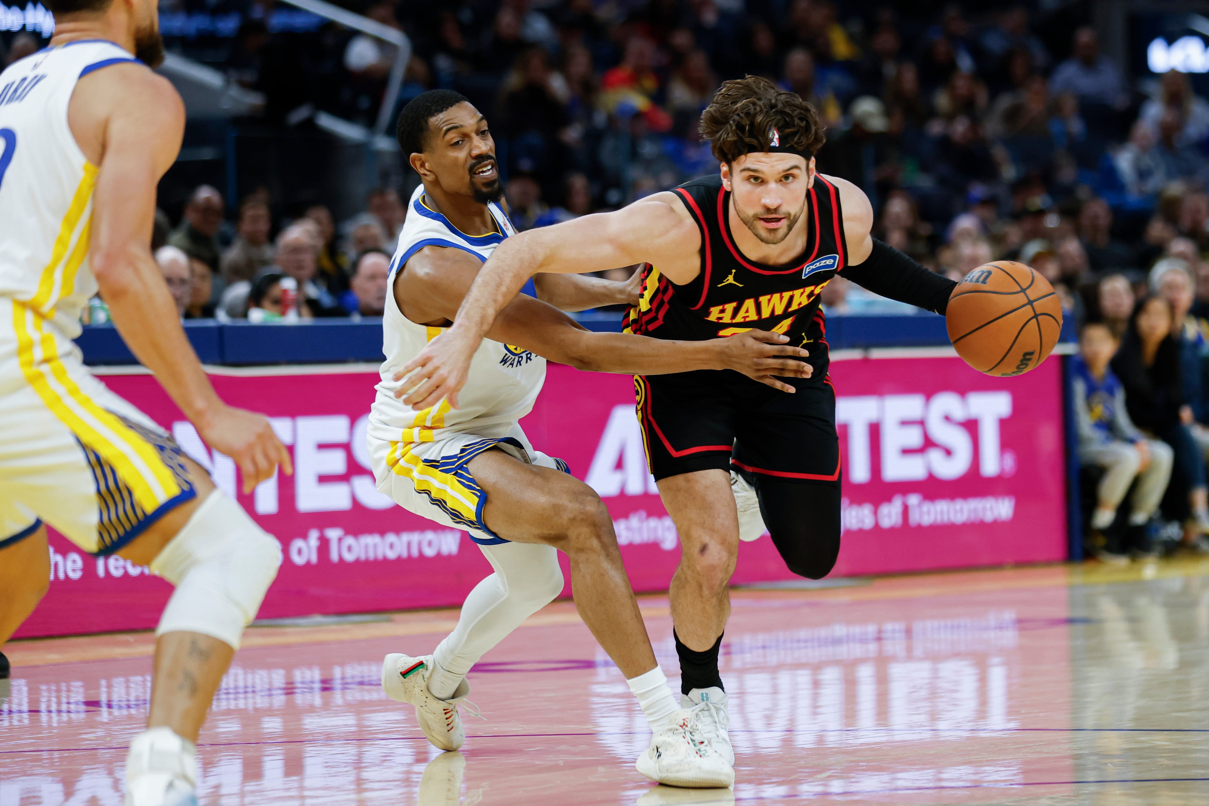 De'Anthony Melton (center) of the Golden State Warriors guards Corey Kispert (right) of the Atlanta Hawks during the fourth quarter of an NBA basketball game in San Francisco, Sunday, Jan. 11, 2026. (Carlos Avila Gonzalez/San Francisco Chronicle via AP)