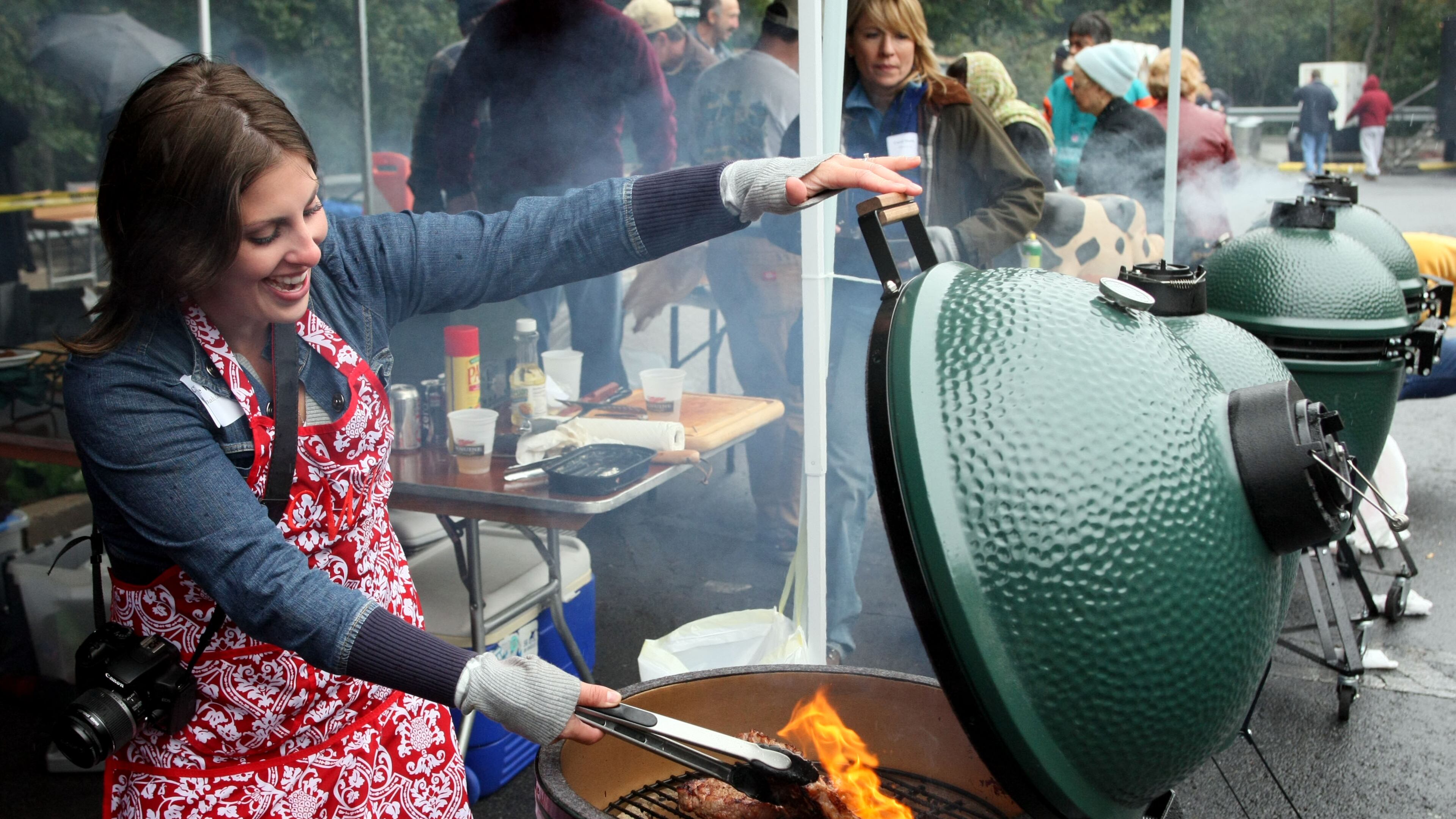 Clare Ward, from Savannah, flips her steaks at the annual EGGtoberfest. Phil Skinner/Staff pskinner@ajc.com