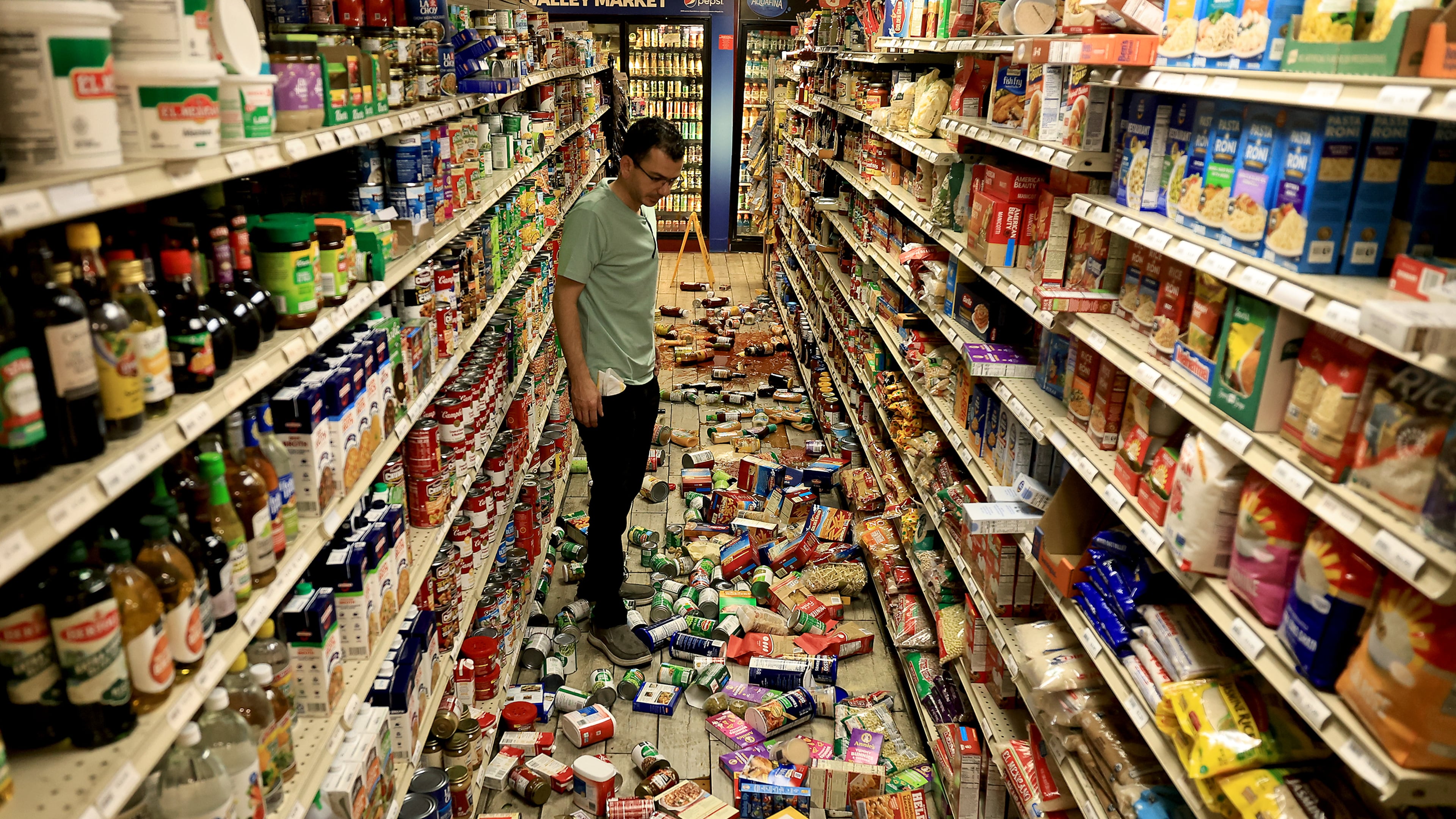 Redwood Valley Market owner Alex Chehada looks at items which fell off the shelves after an earthquake in Redwood Valley, Calif., Wednesday, June 24, 2026. (Kent Porter/The Press Democrat via AP)
