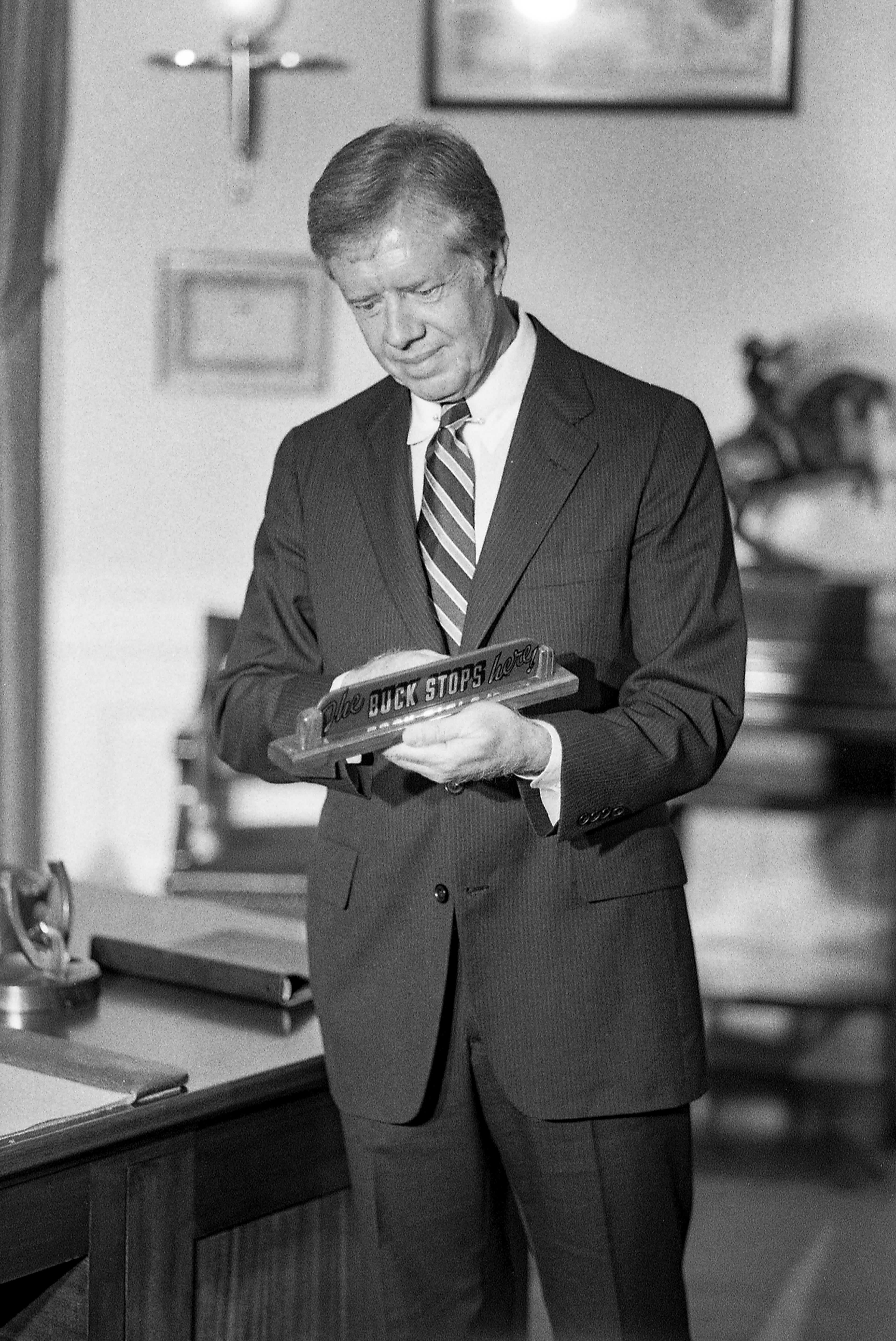 President Jimmy Carter examines "The Buck Stops Here" sign that was on the desk in the Oval Office during Truman's presidency at the Harry S. Truman Library and Museum during his visit there on Sept. 2, 1980. (John Spink / Shot for the Kansas City Times)