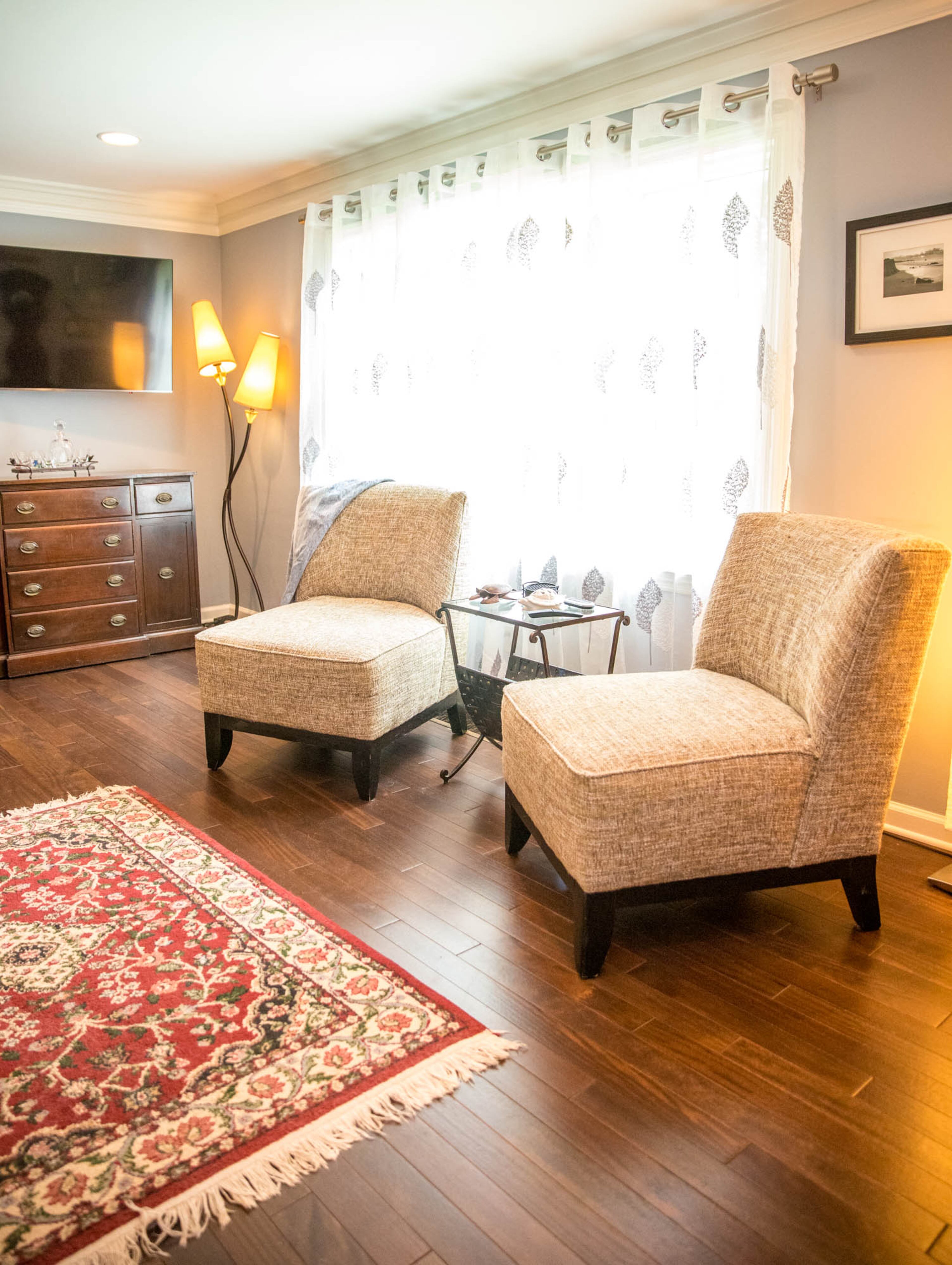 Two chairs from Finders Keepers Consignments and a table from Pier 1 make a seating area in the living room of Adam Perry and Ben Ratossa's Avondale Estates home. On the table sit two of the collection of turtles that Perry and Ratossa have worked into the decor of their home. An Oriental rug from Sharian Rugs adds a touch of color to the space.