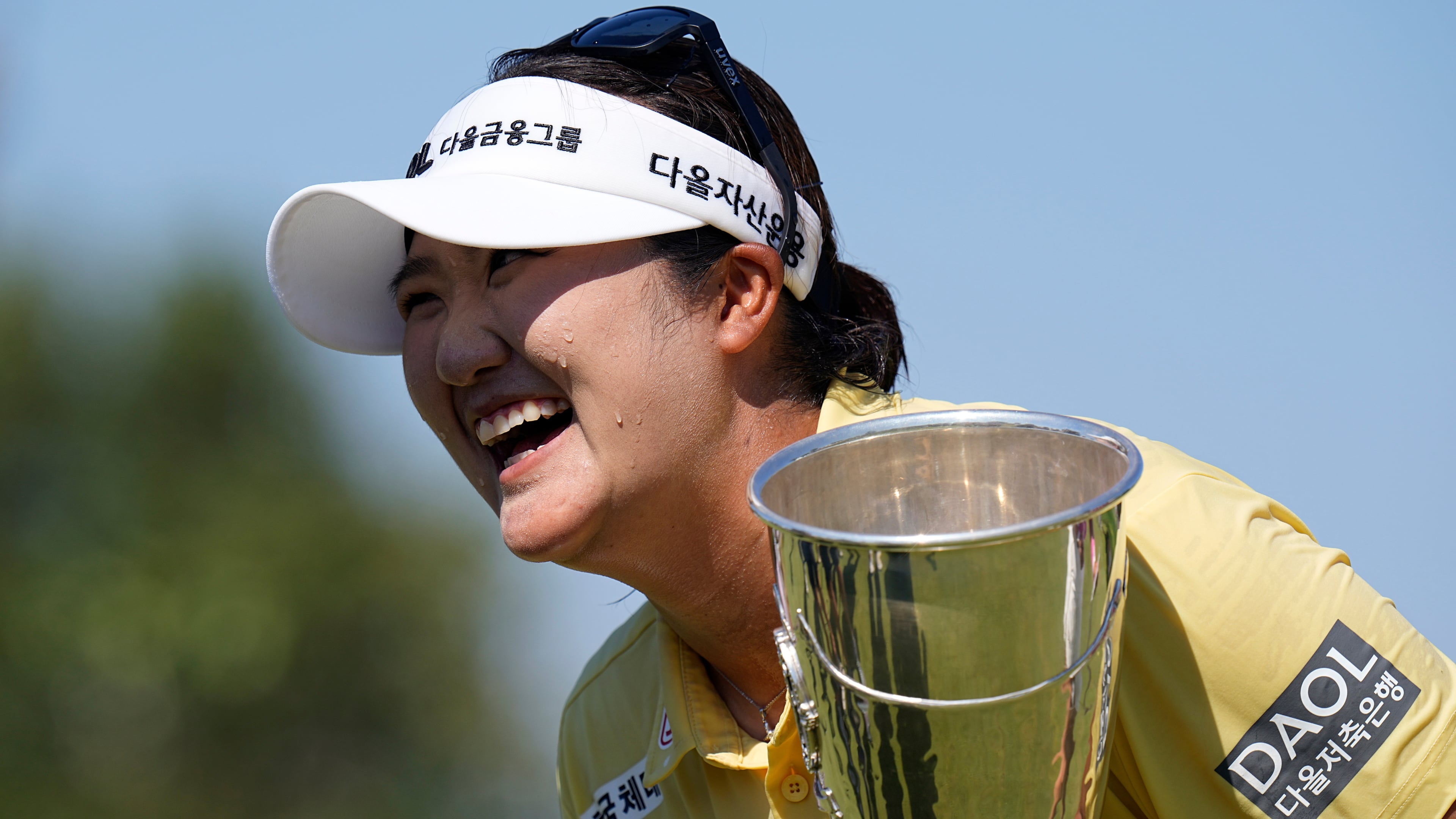 Haeran Ryu, of South Korea, celebrates with her trophy after winning the Evian Championship women's golf tournament, in Evian, eastern France, Sunday, July 12, 2026. (AP Photo/Laurent Cipriani)