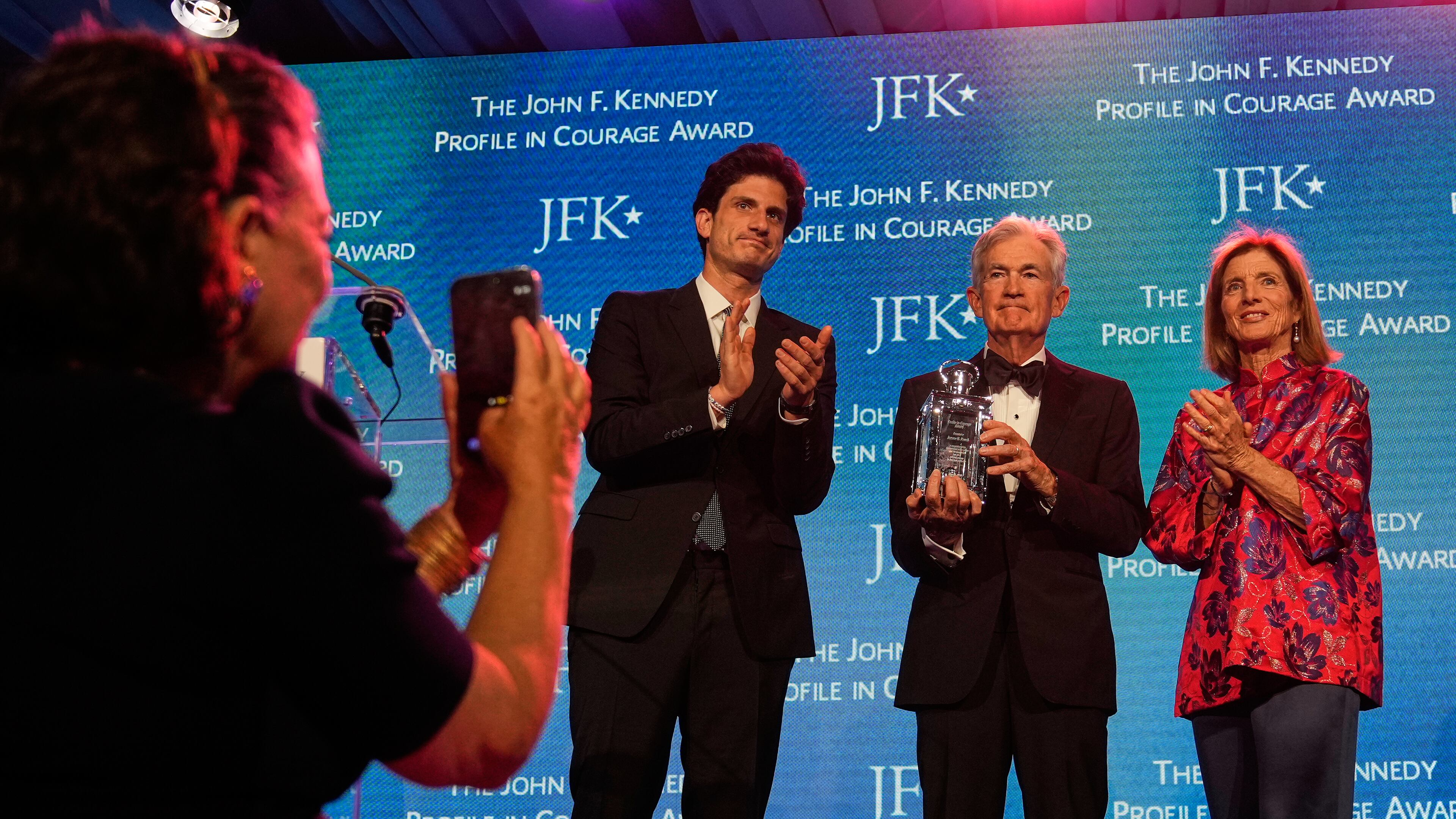 Federal Reserve Board Governor Jerome Powell, the former Federal Reserve chair, center, stands with former ambassador Caroline Kennedy, right, and her son Jack Schlossberg, as Powell's wife Elissa Leonard takes a picture at left, while being honored with the Profile in Courage Award at the John F. Kennedy Presidential Library, Sunday, May 31, 2026, in Boston. (AP Photo/Charles Krupa)
