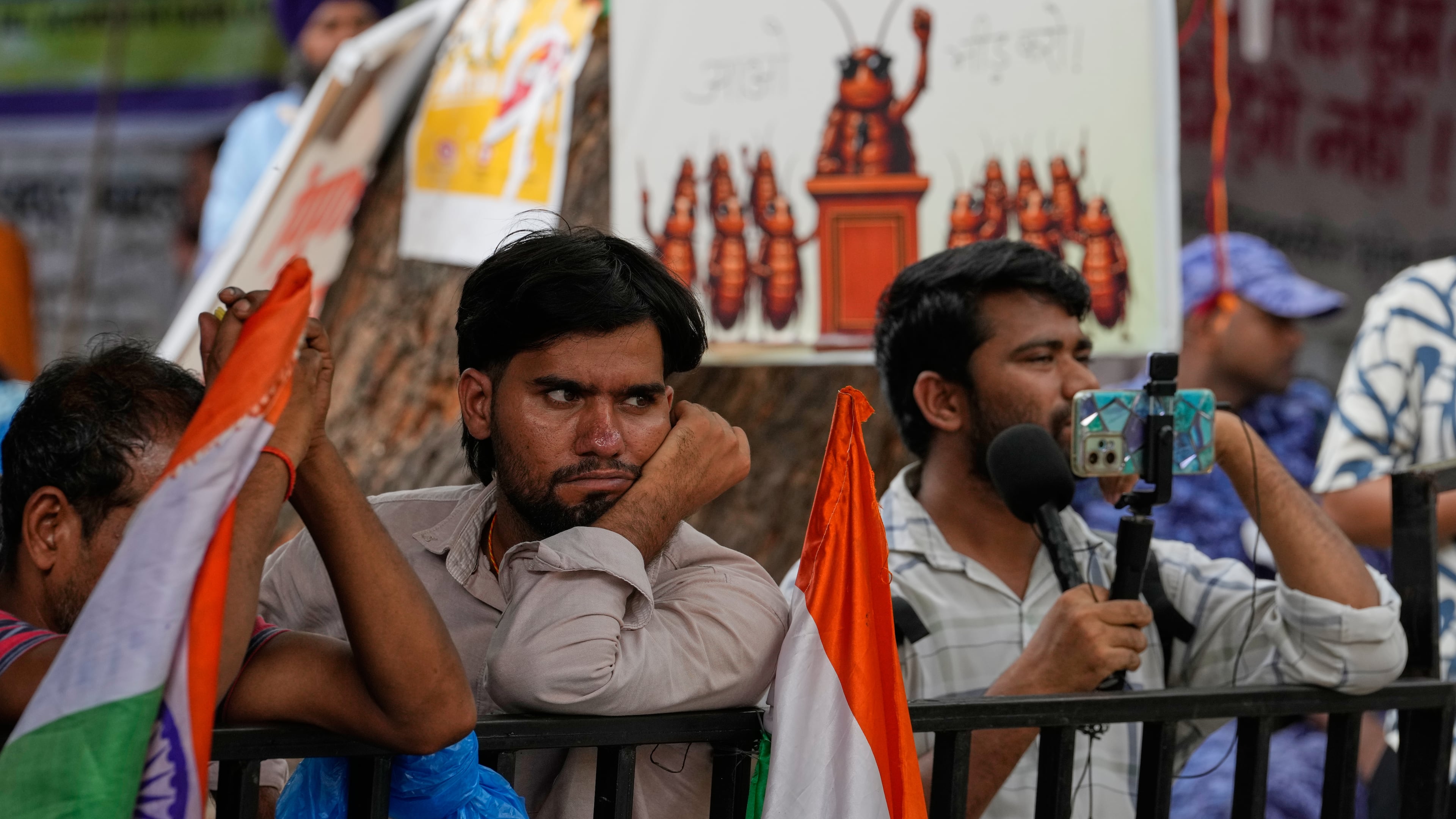 Supporters listen to a speaker during a protest by the Cockroach Janta Party demanding the resignation of Education Minister Dharmendra Pradhan over alleged examination irregularities and repeated paper leaks, in New Delhi, India, on July 10, 2026. (AP Photo/Manish Swarup)