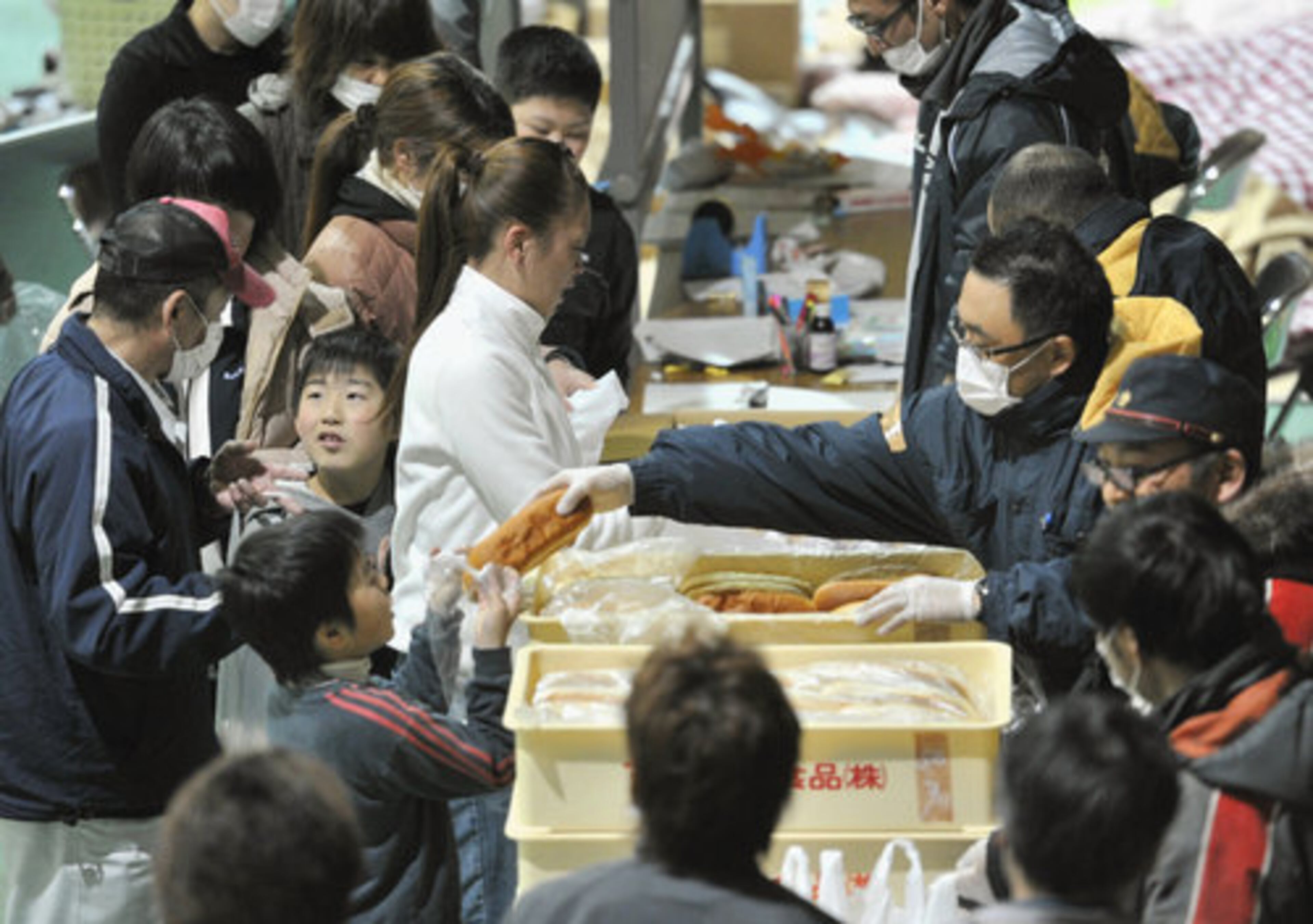 Evacuees from the area nearTokyo Electric Power Co's Fukushima Daiichi Nuclear Power plant damaged by Friday's earthquake receive food at an evacuation center.